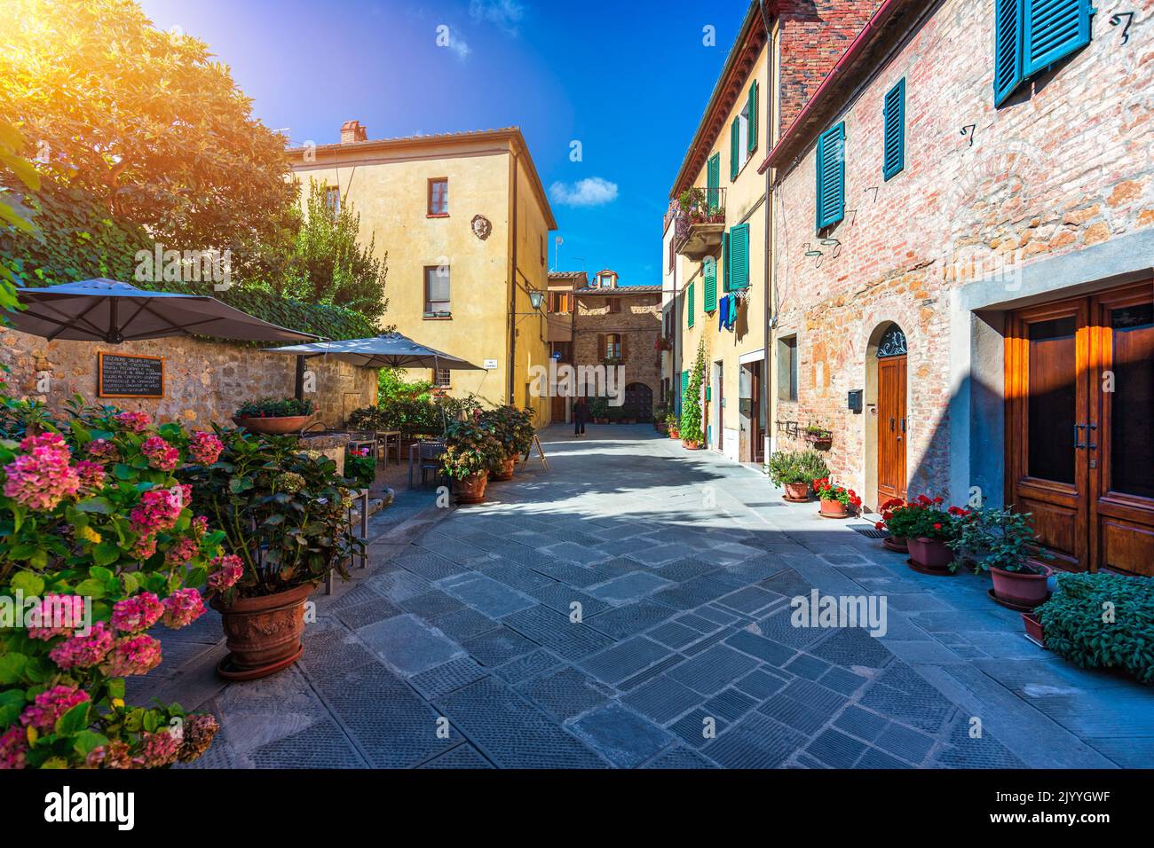 Cozy street decorated with colorful flowers, Pienza, Tuscany, Italy, Europe. Narrow street in the charming town of Pienza in Tuscany. Beautiful street Stock Photo