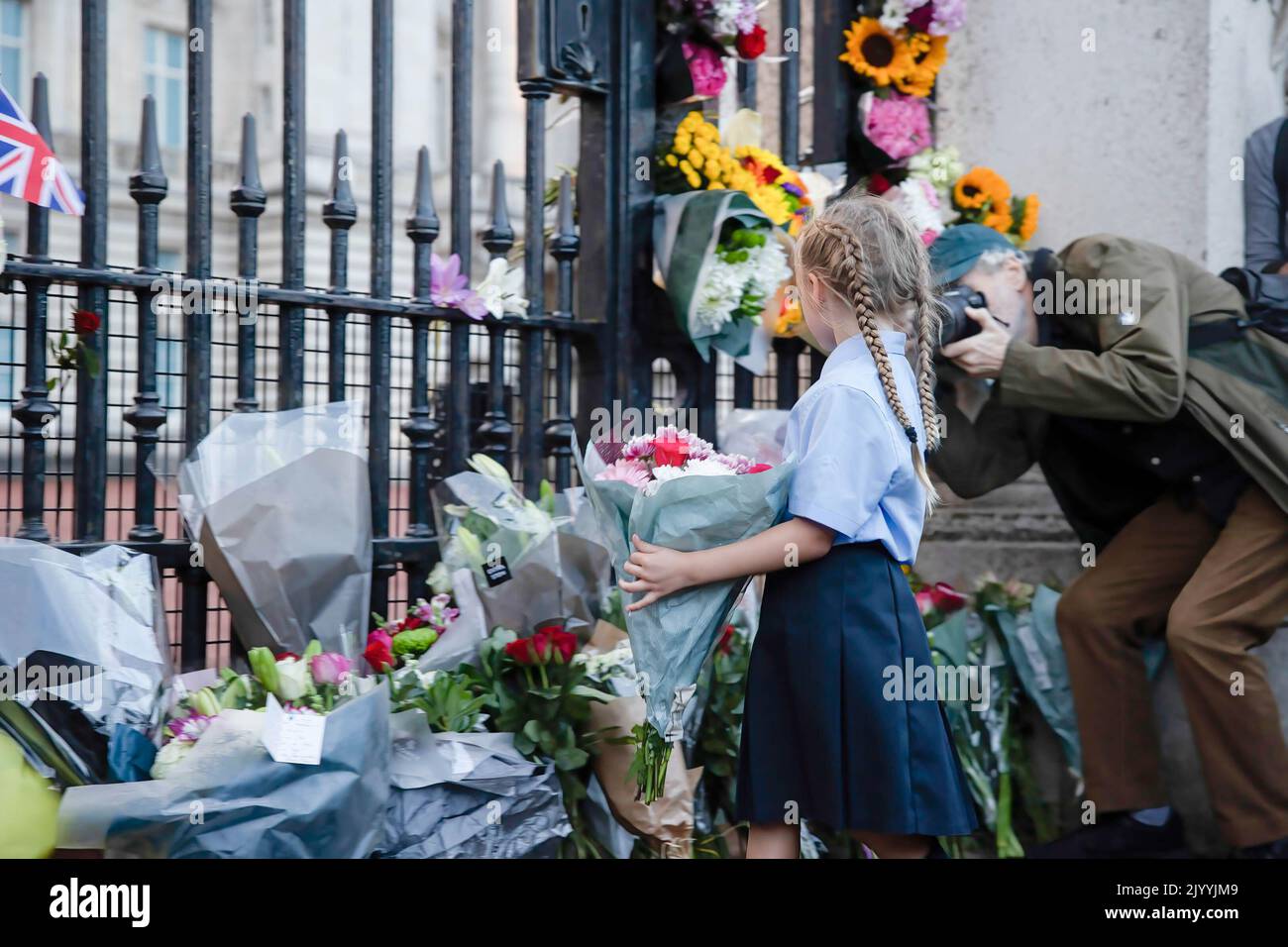 London, UK. 08th Sep, 2022. A young girl seen laying flowers at the gate of Buckingham Palace to