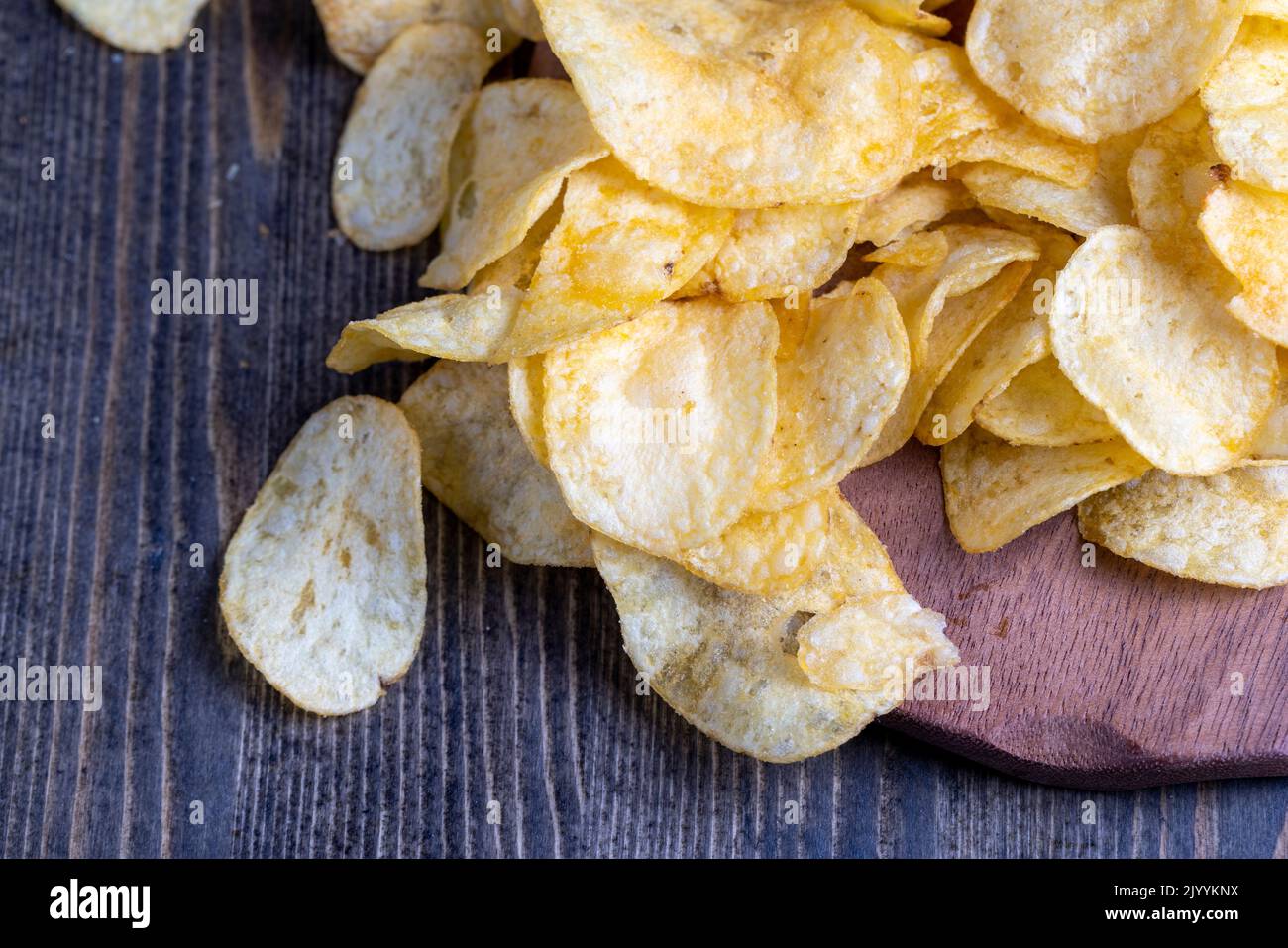 scattered potato chips with natural spices , fried potato chips with spices and flavorings in