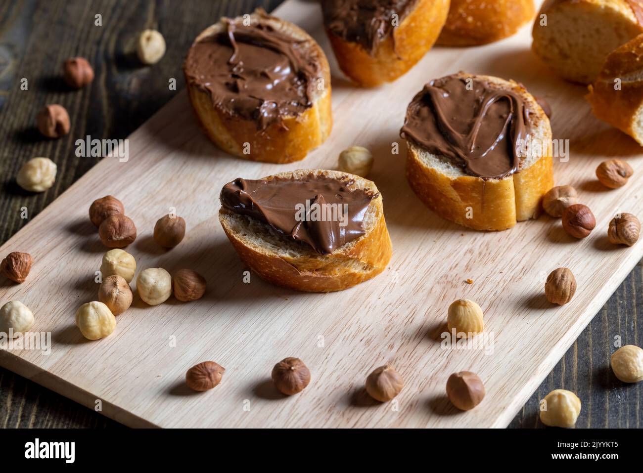chocolate butter spread on a baguette, sweet chocolate butter spread on a baguette during the preparation of a simple dessert at home Stock Photo