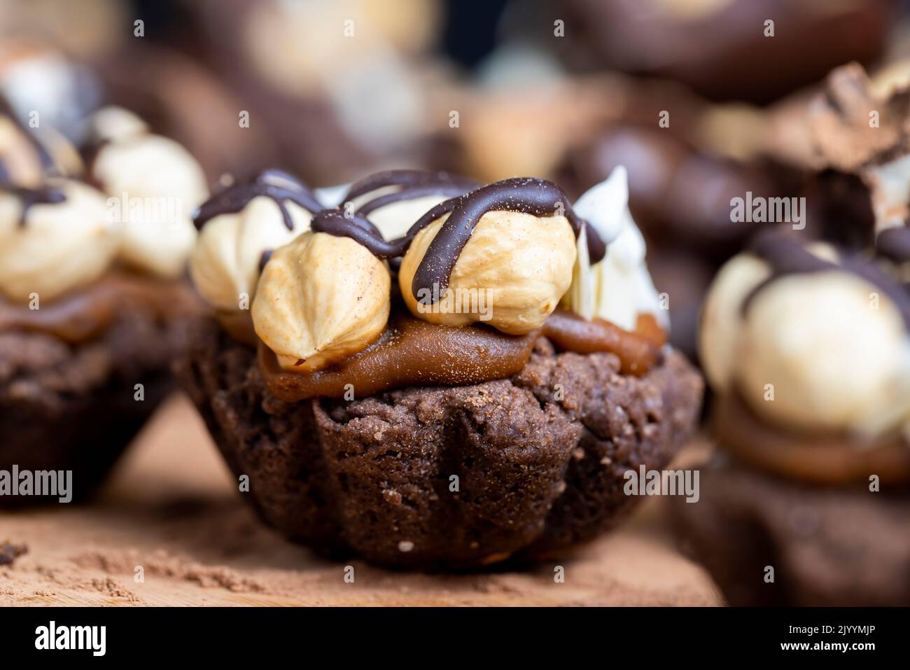 multicomponent cake made of caramel and nuts in chocolate, mixed hazelnut cake with almonds and caramel Stock Photo