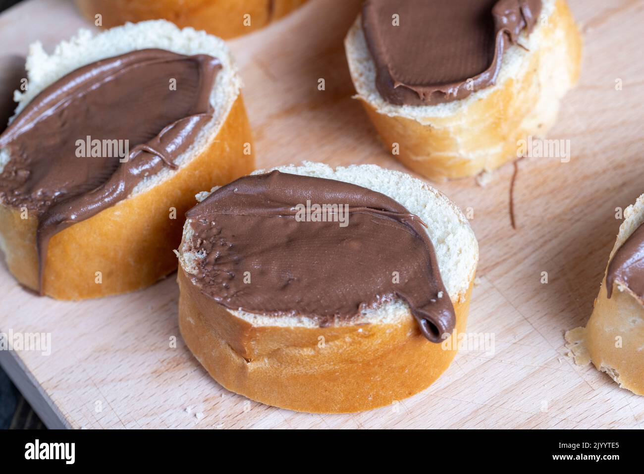 Chocolate butter spread on bread while cooking breakfast, making breakfast from wheat bread with bran and chocolate butter Stock Photo