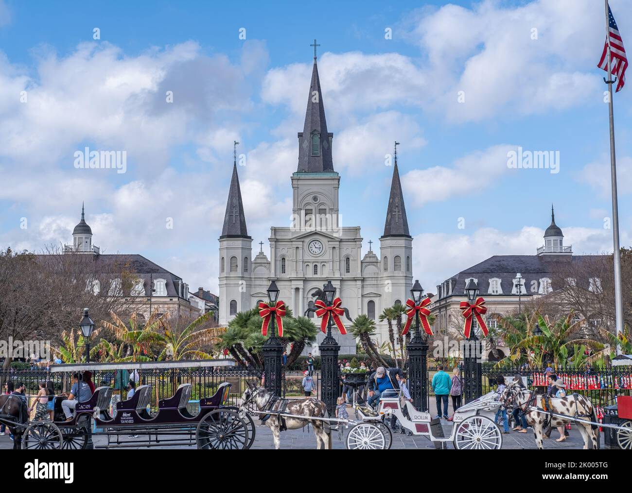 NEW ORLEANS, LA, USA - NOVEMBER 30, 2019: Cityscape of St. Louis Cathedral, the Cabildo, the Presbytere, mule-drawn carriages, and Christmas decor Stock Photo