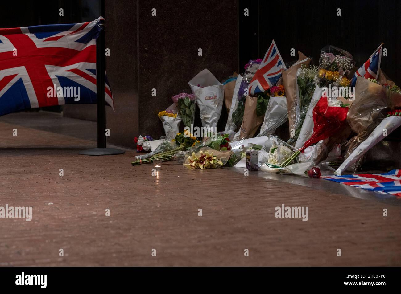 NEW YORK, NEW YORK - SEPTEMBER 08: Floral tributes, candles and British flags for Her Majesty Queen Elizabeth II are seen outside of The British Consulate General in New York on September 8, 2022 in New York City. According to a statement issued by Buckingham Palace on 08 September 2022, Britain's Queen Elizabeth II has died at her Scottish estate, Balmoral Castle, on 08 September 2022. The 96-year-old Queen was the longest-reigning monarch in British history. Stock Photo