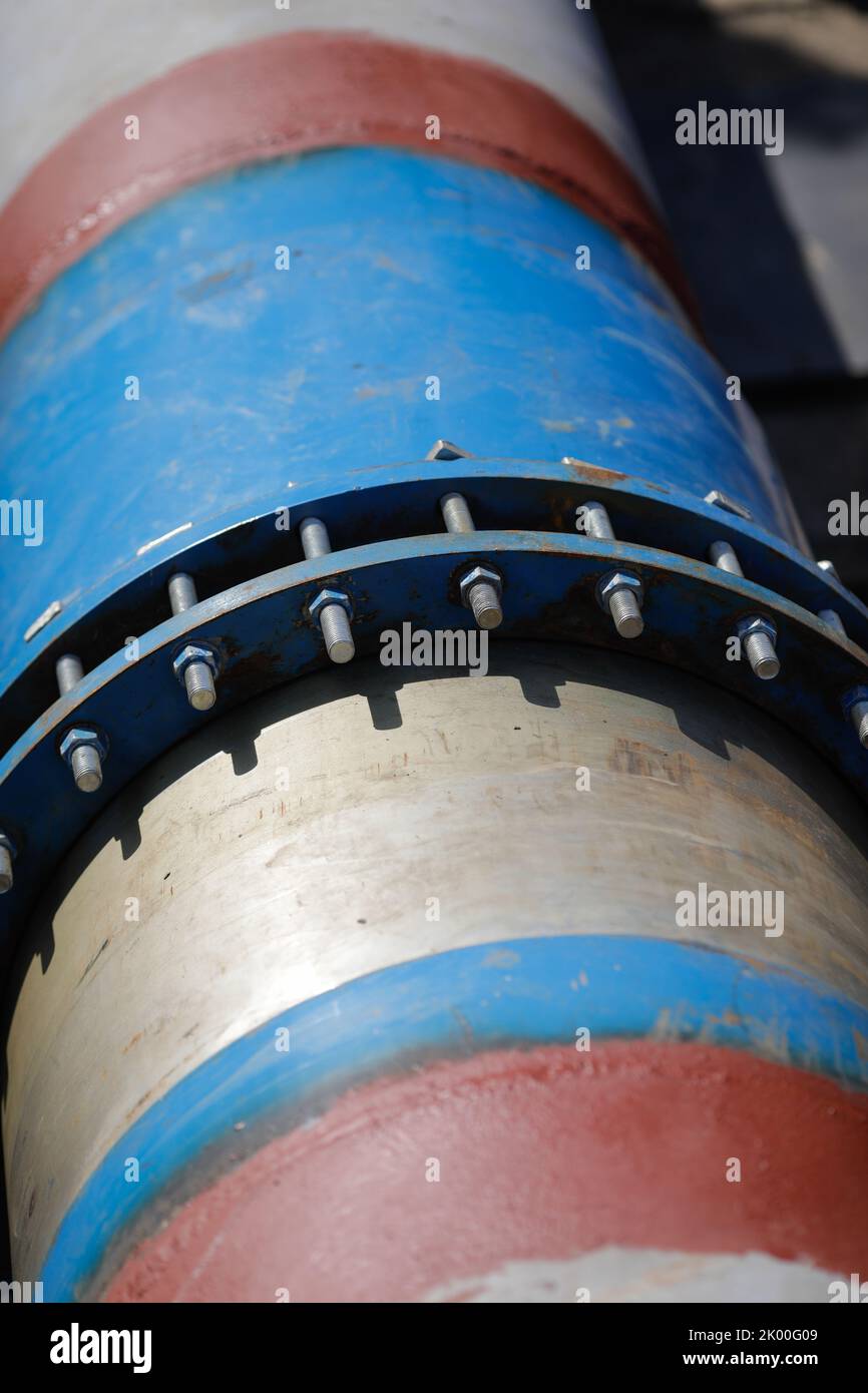 Shallow depth of field (selective focus) details with a metallic pipeline for hot water. Stock Photo