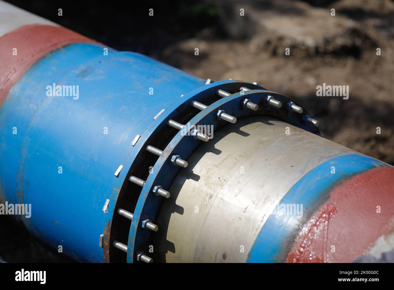Shallow depth of field (selective focus) details with a metallic pipeline for hot water. Stock Photo