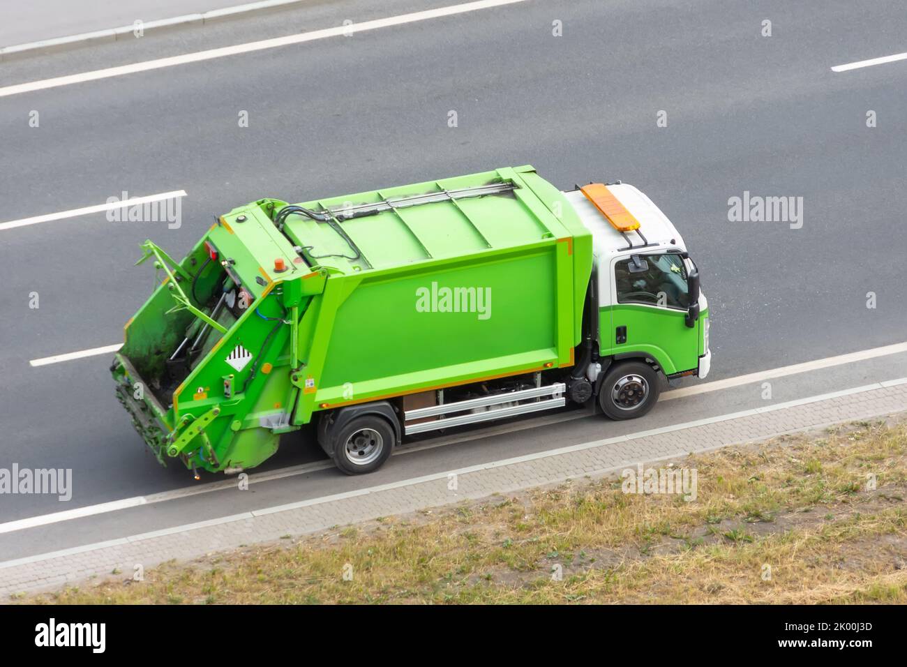 Recycling green truck rides on the road in the city Stock Photo