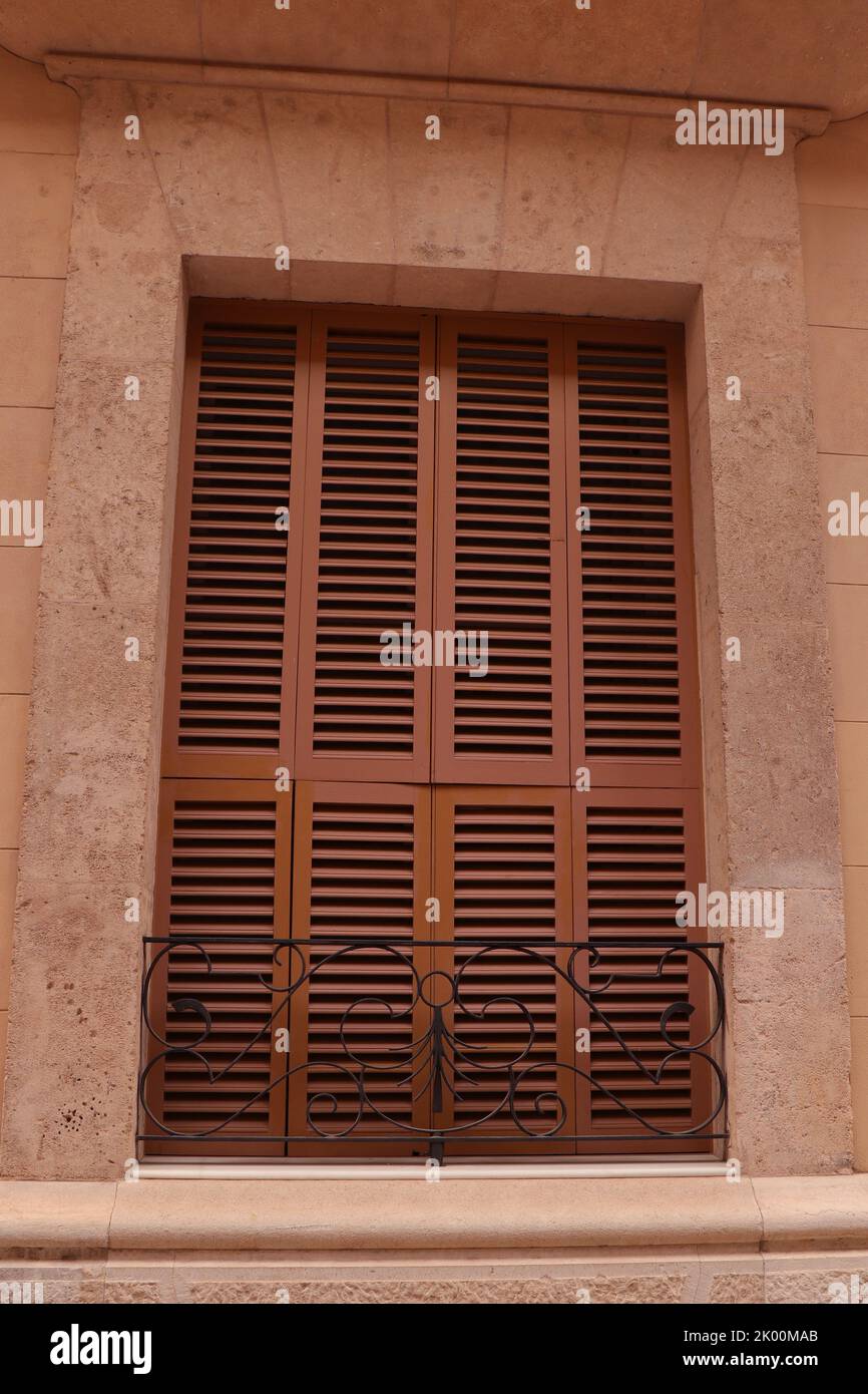 Windows with wooden shutters and an iron railing Stock Photo