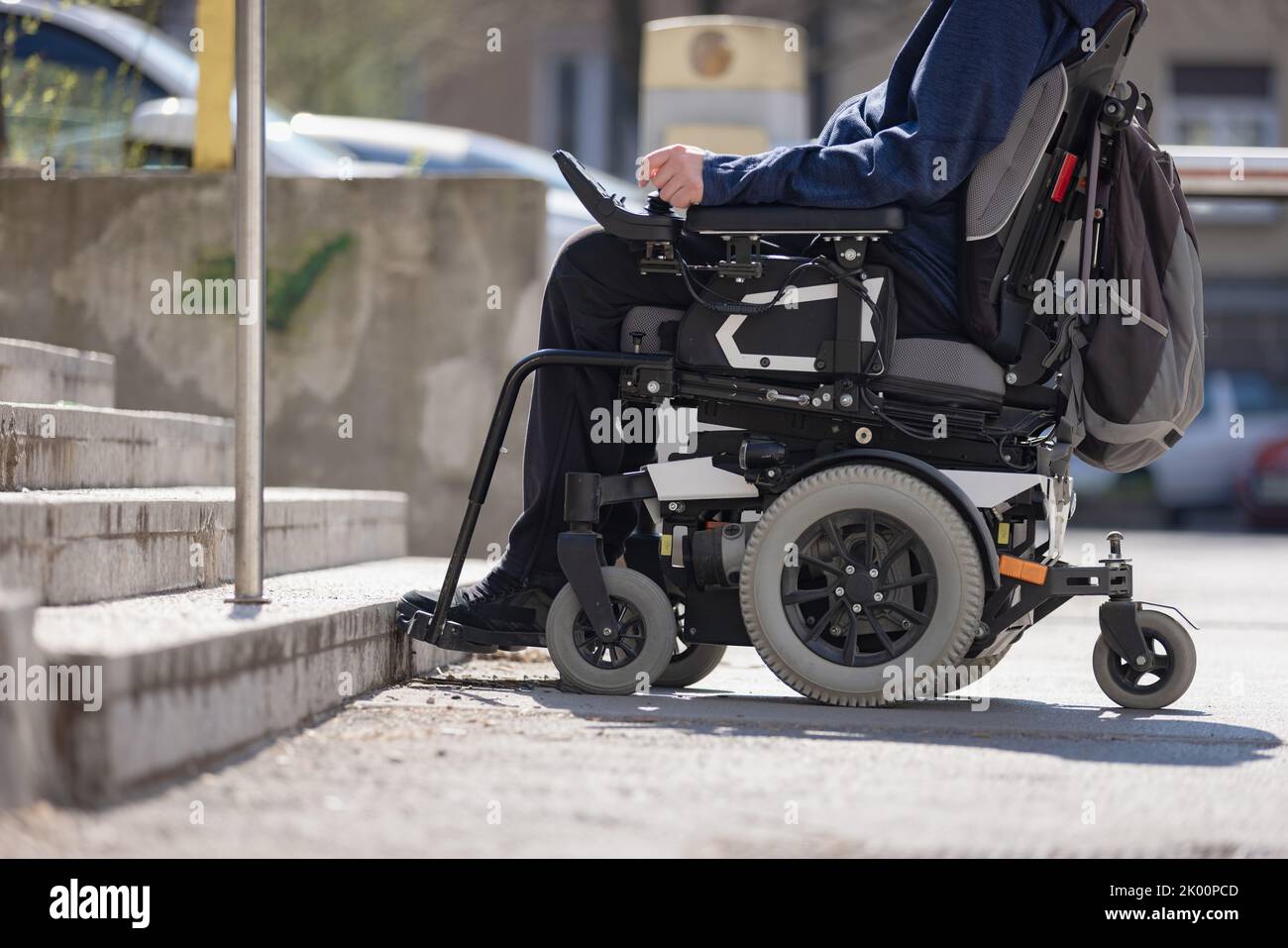 Man with disability on wheelchair stopped in front of staircase
