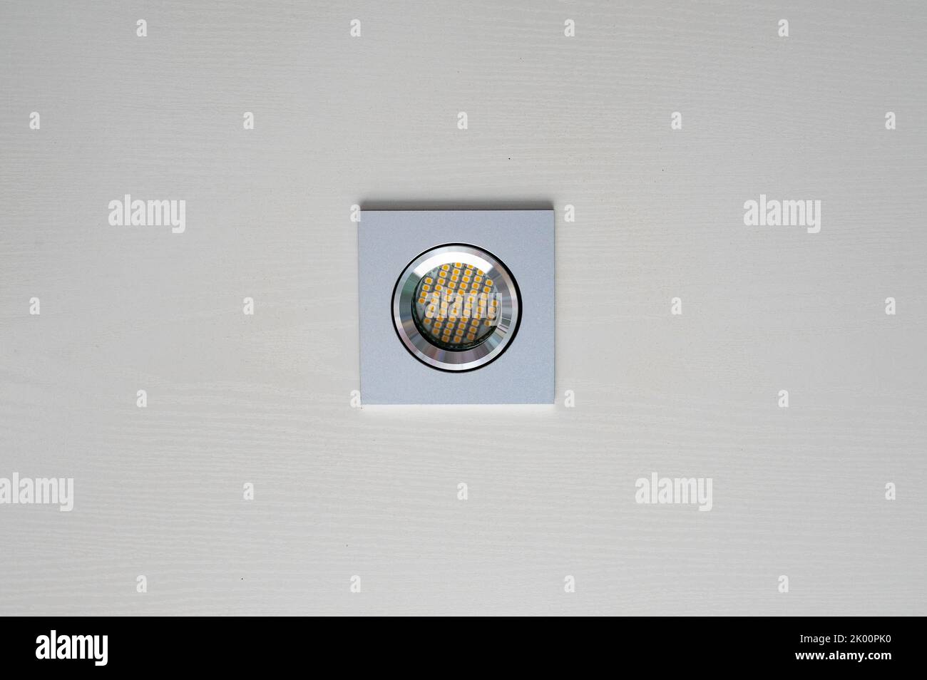 Energy saving LED spotlight in aluminum housing in white wooden ceiling