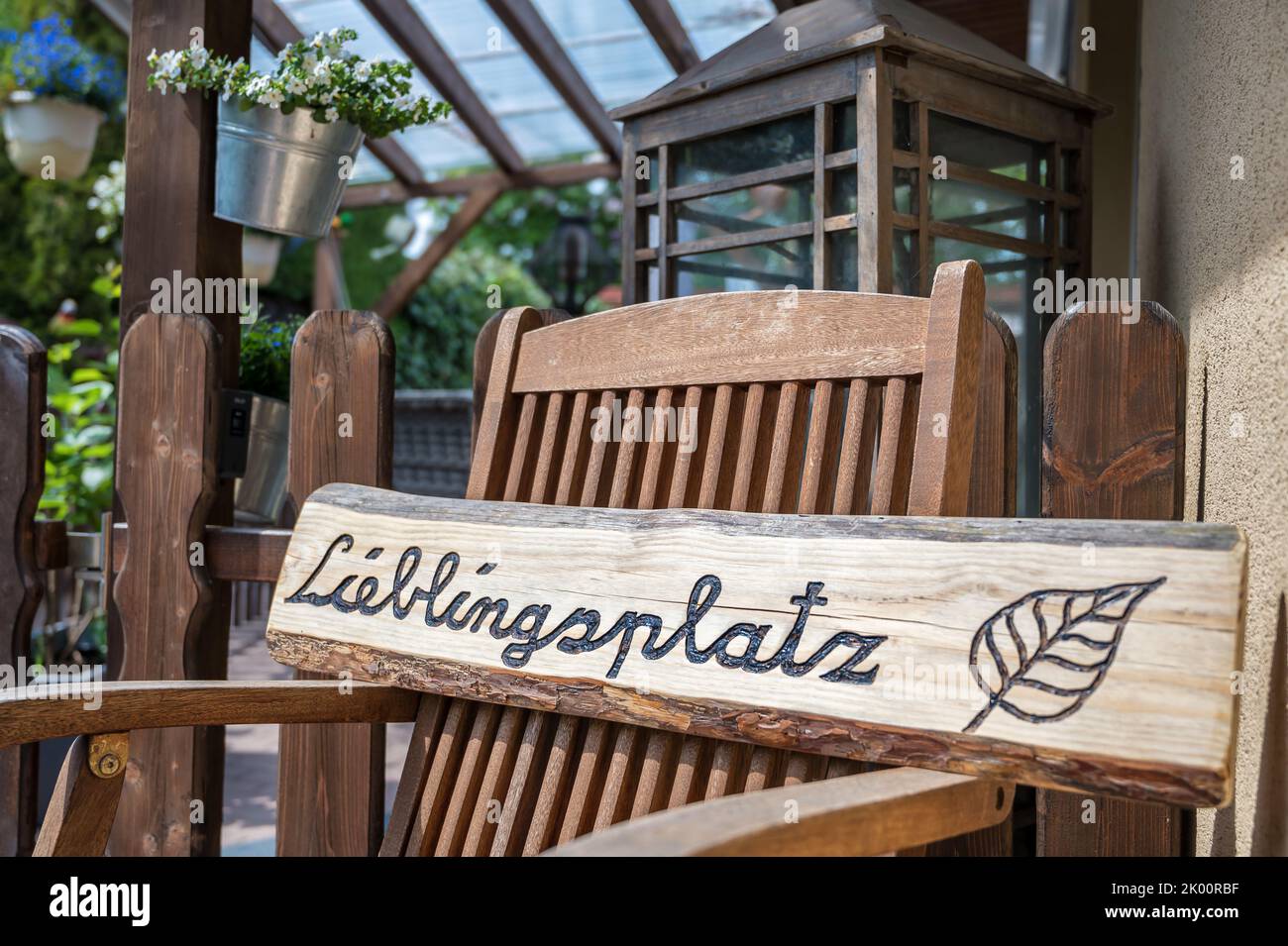 Self-carved wooden sign with the word favorite place in german language in front of a cozy terrace Stock Photo