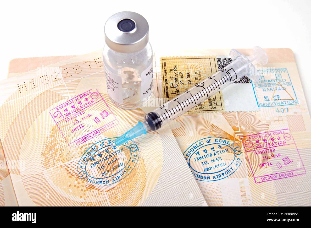 stamped passport pages and vaccination syringe  with vial Stock Photo