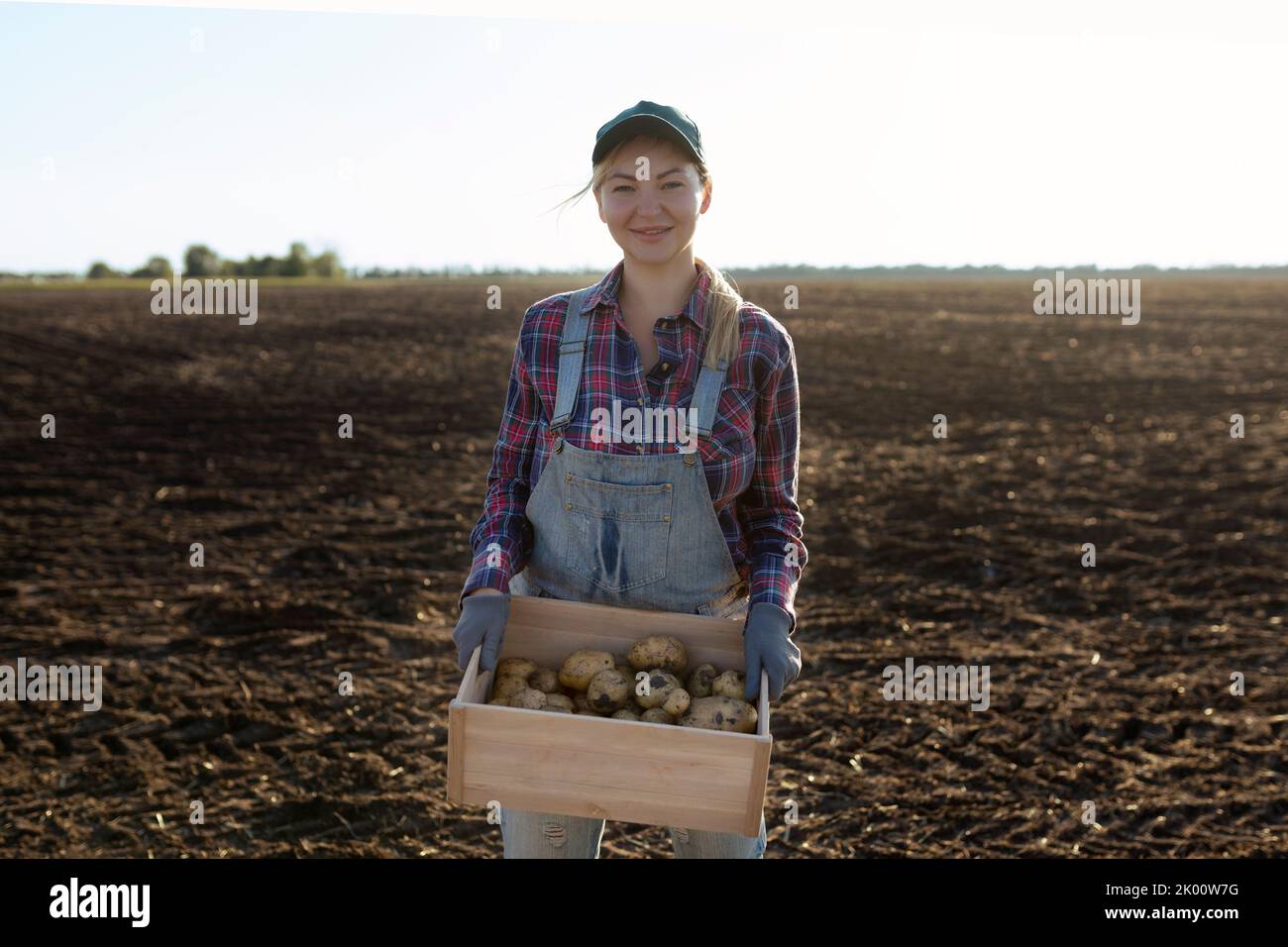 Happy smiling caucasian female potato farmer or gardener. Agriculture - food production, harvest concept Stock Photo