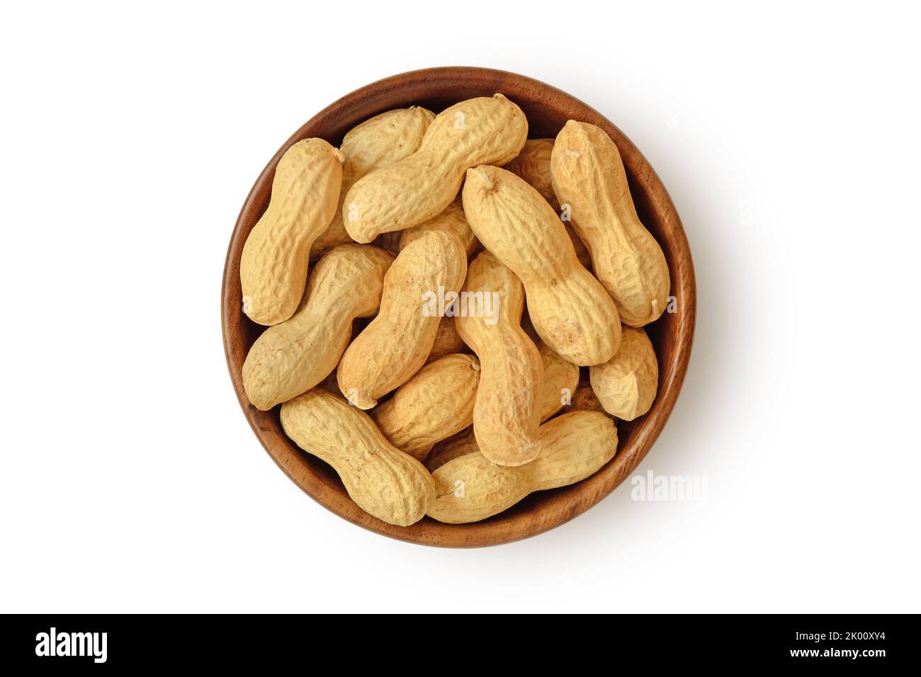 Shelled peanuts in wooden bowl on white background Stock Photo