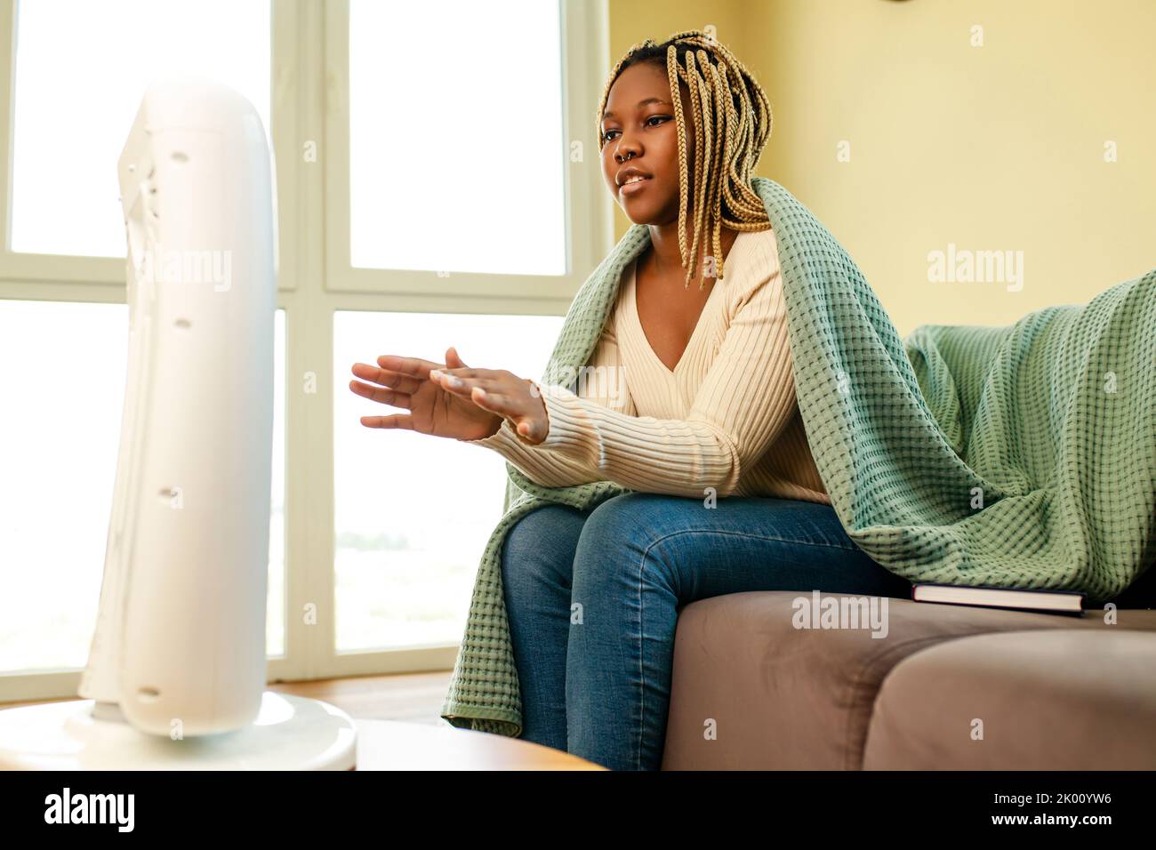 latin american woman with blanket in cold room with heater Stock Photo Alamy