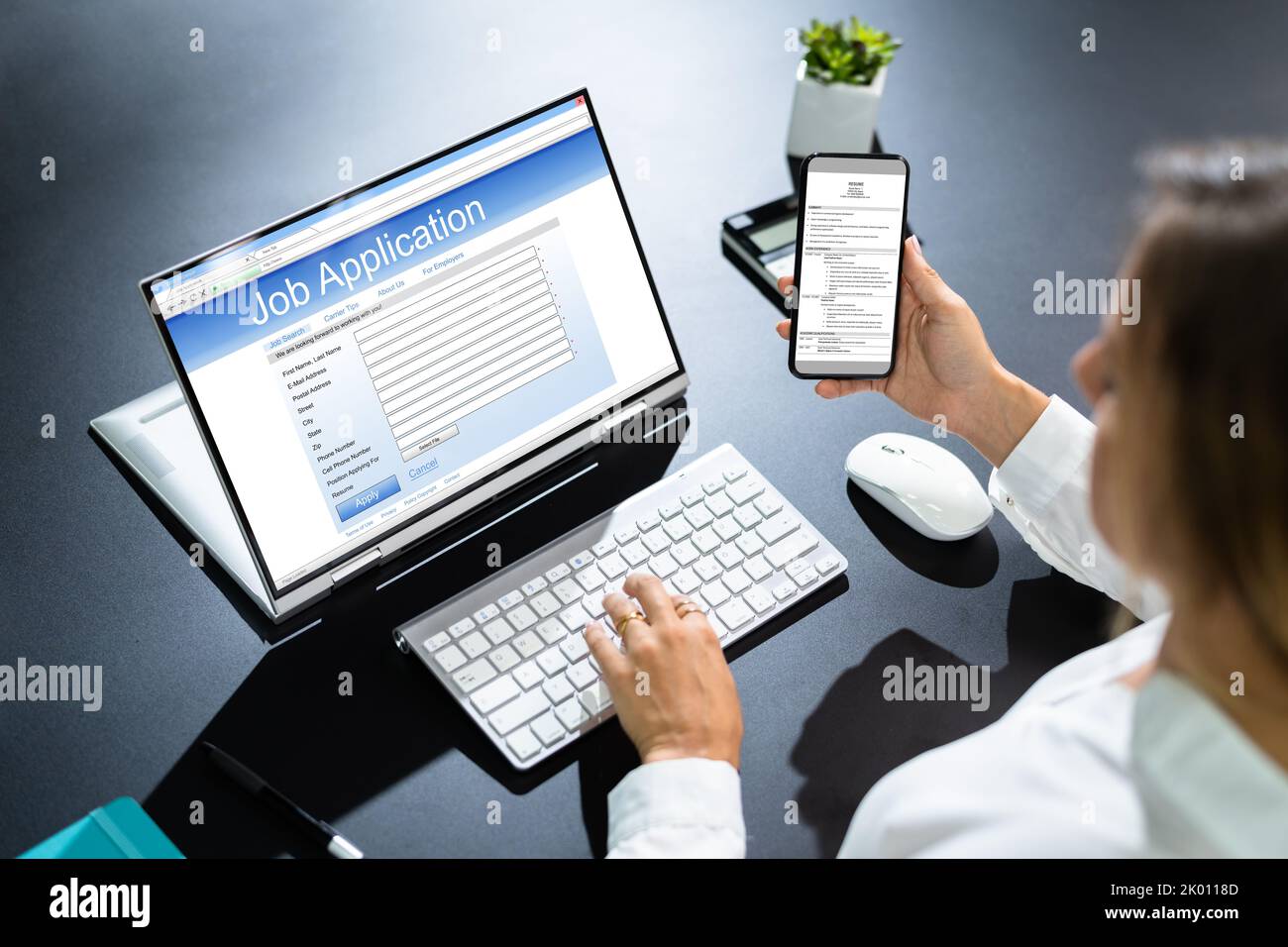 Person Hands Filling Online Job Application On Mobile Phone At Desk Stock Photo