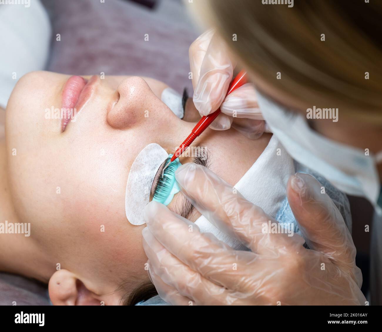 The master uses a multifunctional tool for laminating eyelashes Stock