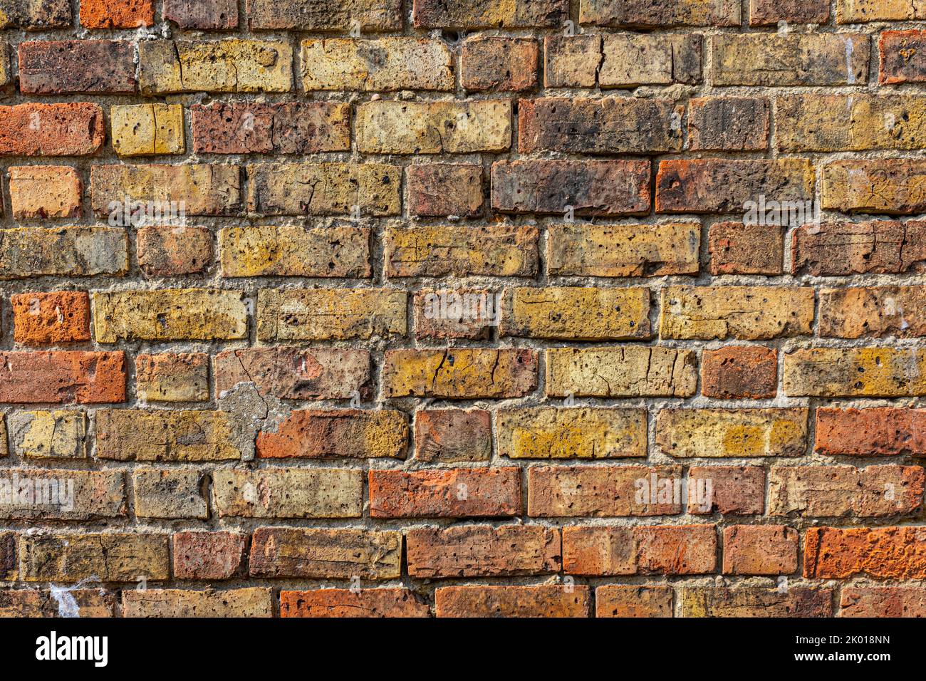 A red, yellow and brown old brick wall. Stock Photo