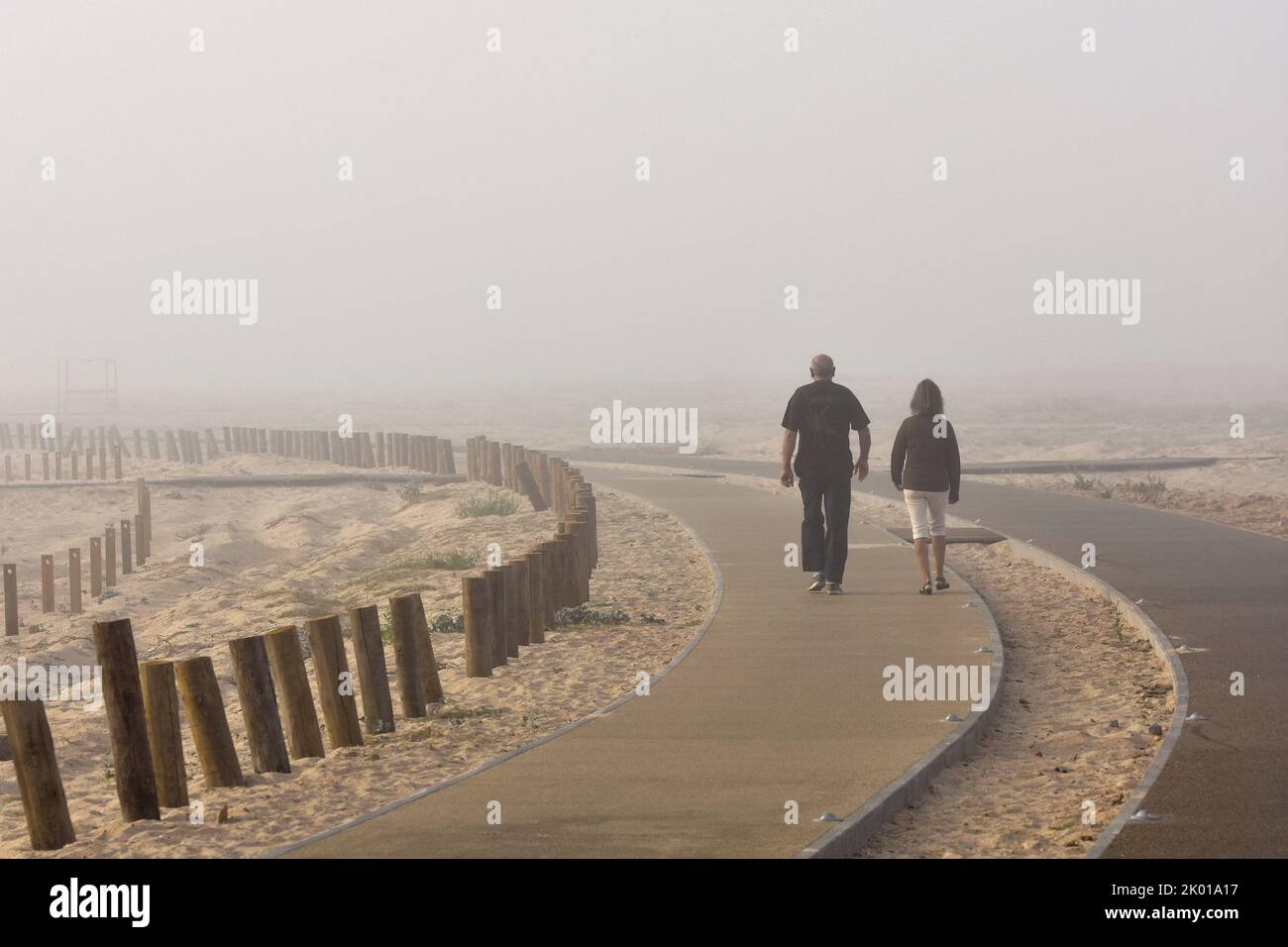 People walking in morning fog, Figueira da Foz Portugal. Stock Photo