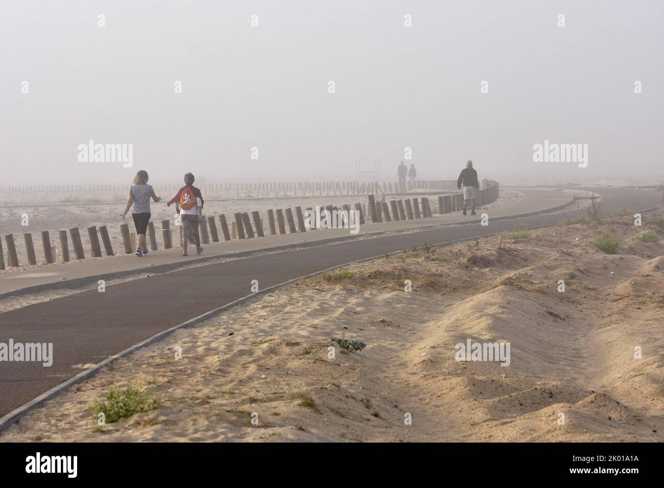 People walking in morning fog, Figueira da Foz Portugal. Stock Photo