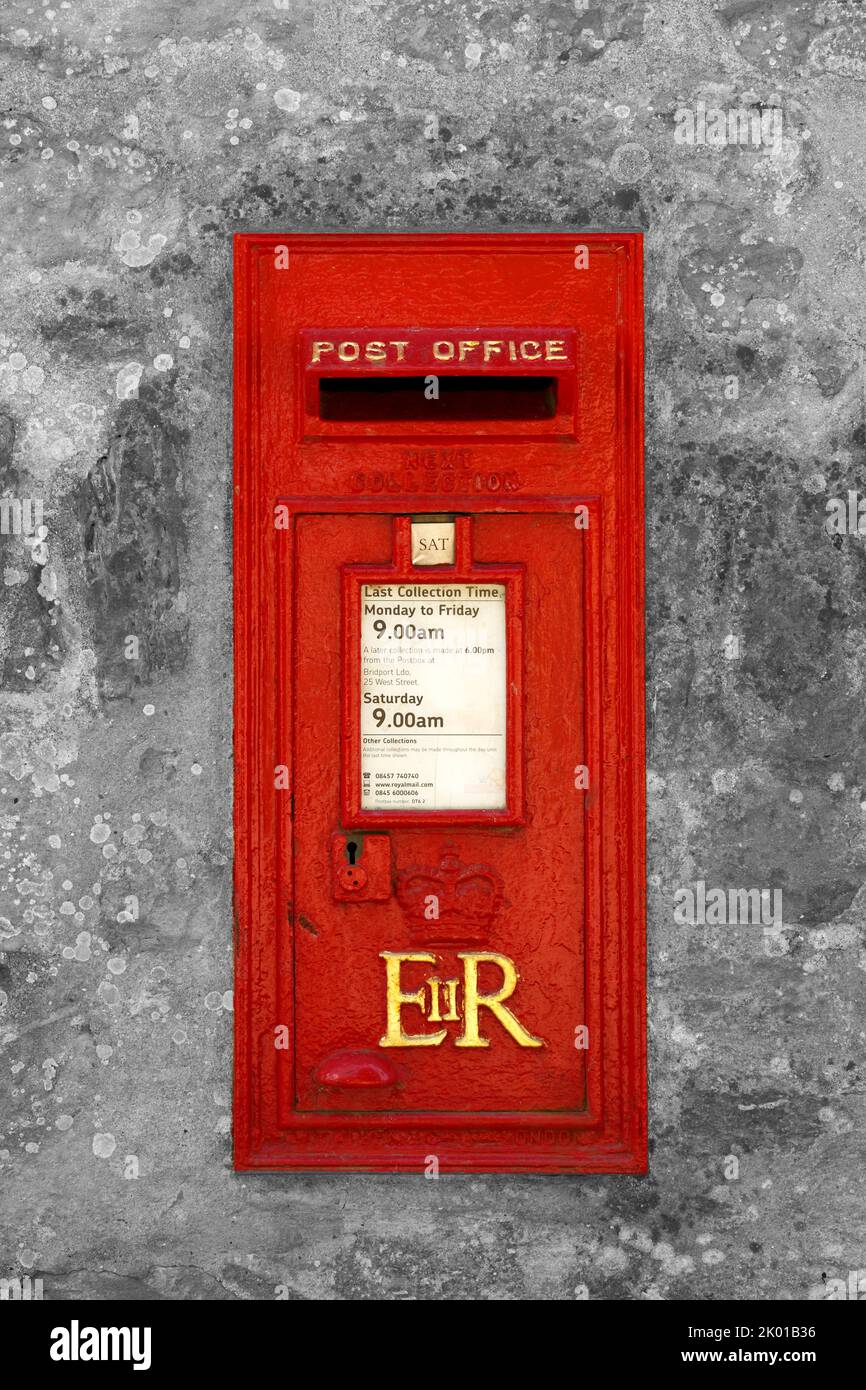Queen Elizabeth II postbox. Red paint with Gold lettering. Set in a stone wall. Royal Mail. Stock Photo