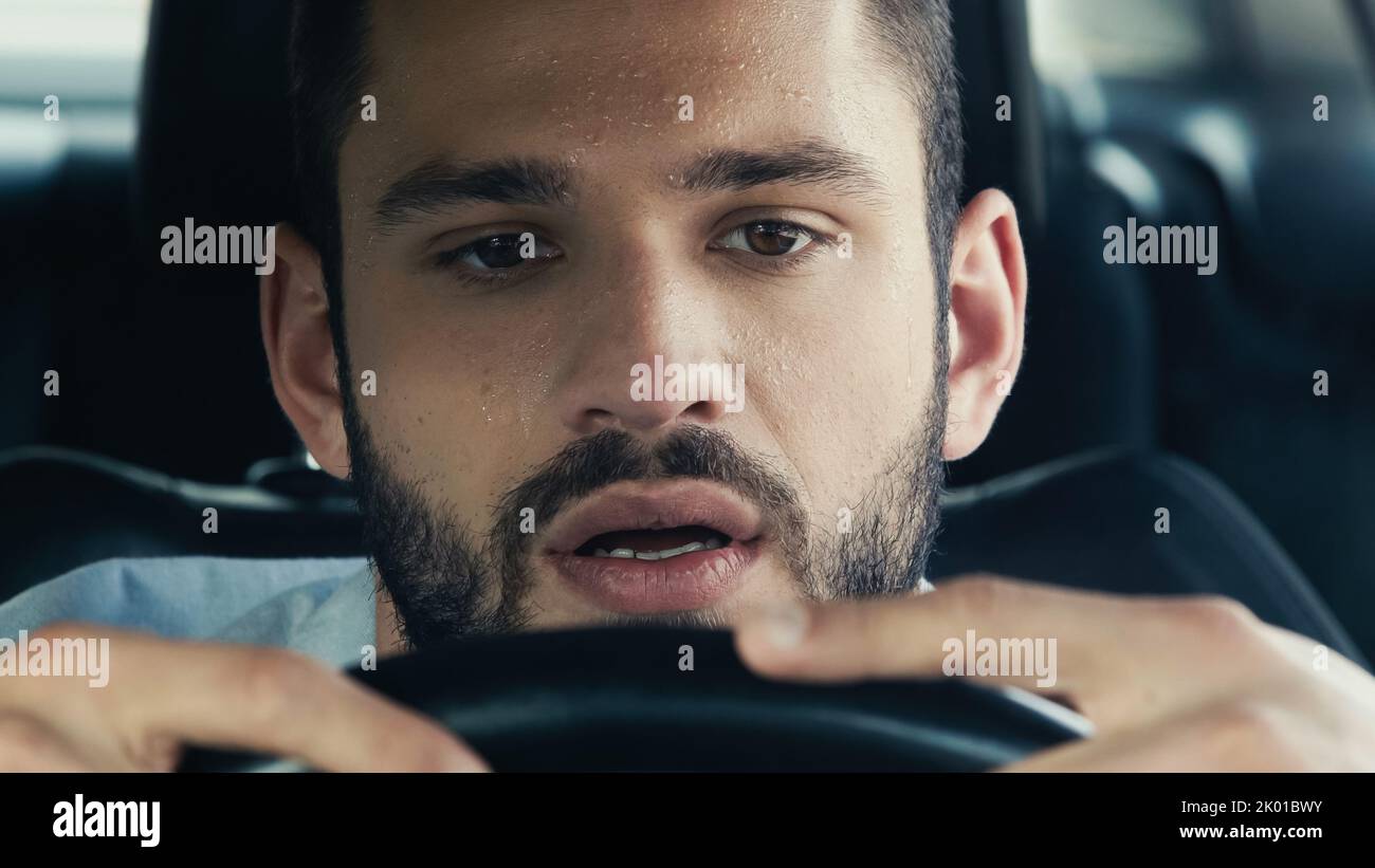 portrait of man with sweat on forehead driving car in hot summer day,stock image Stock Photo