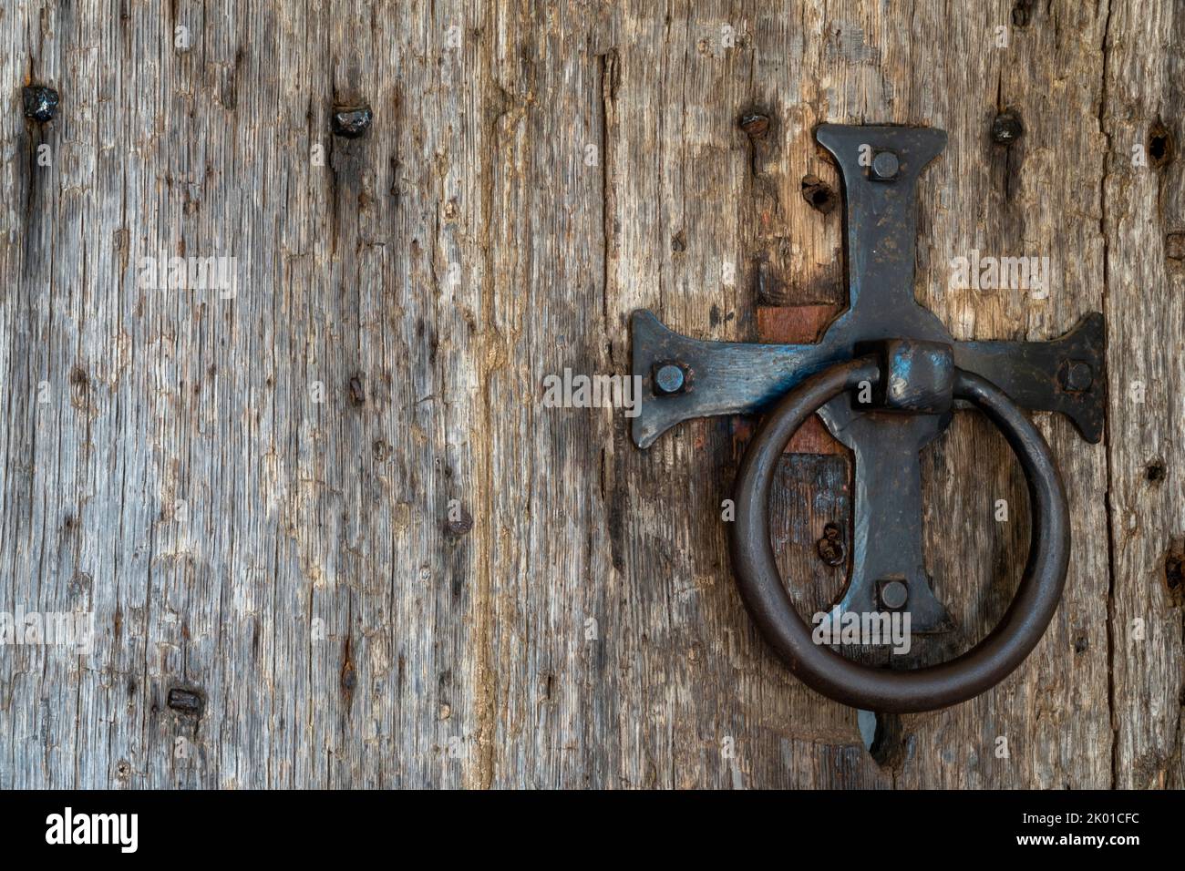Antique church iron door furniture forming a cross and ring on a