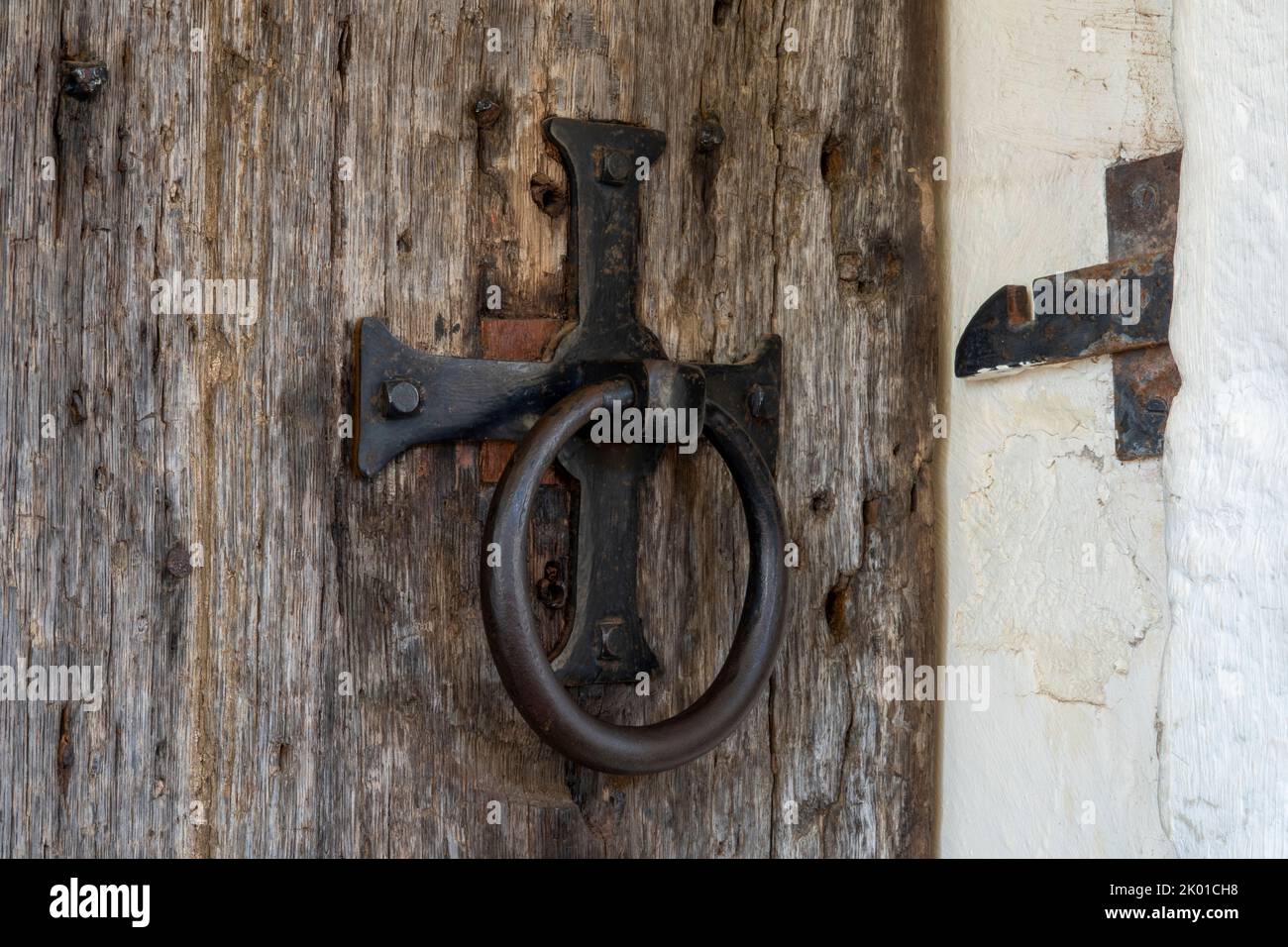 Antique church iron door furniture forming a cross and ring on a