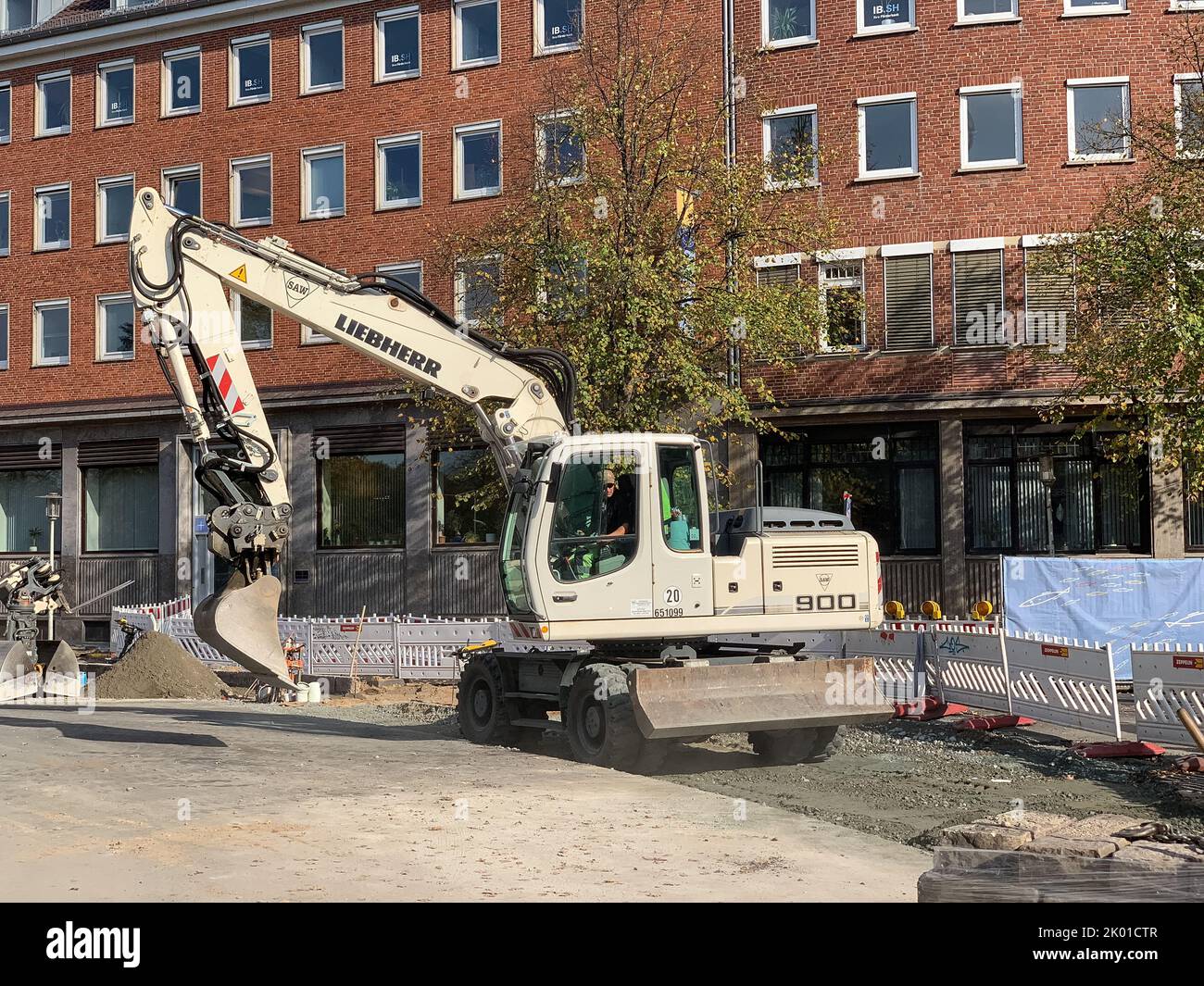 Erneuerung des Straßenbelags in der Kieler Innenstadt, ein Schaufelradbagger trägt Kies auf Stock Photo