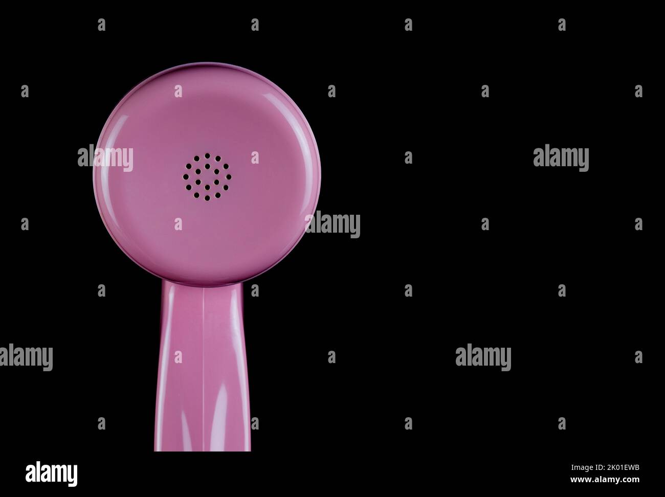 Pink telephone receiver earpiece section isolated on a black background Stock Photo