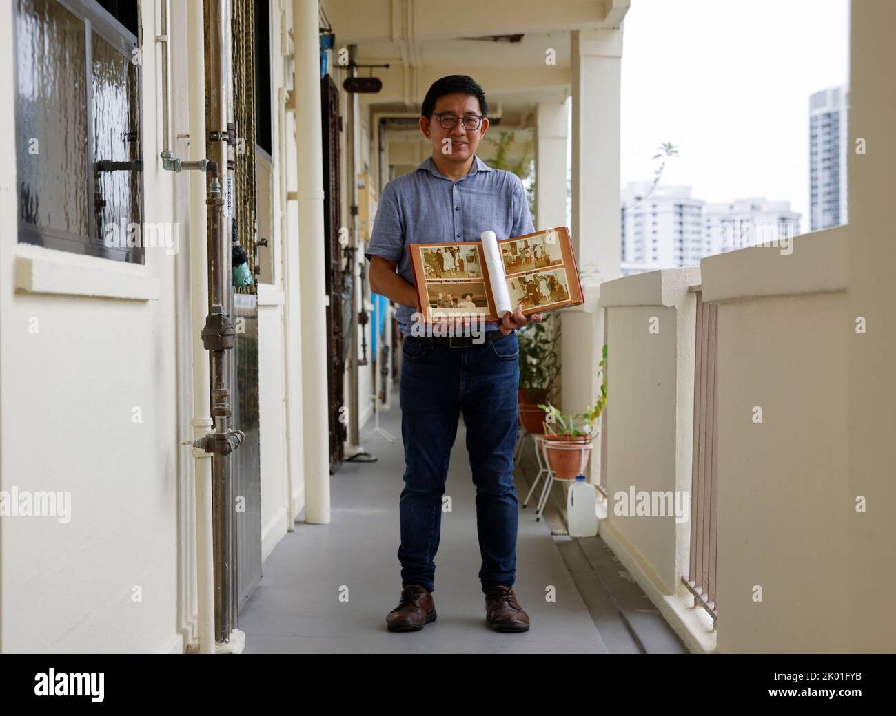 Researcher Jerome Lim, 57, shows photos of Queen Elizabeth's 1972 visit to his and his parents' public housing apartment, outside the apartment unit in Singapore September 9, 2022. REUTERS/Edgar Su Stock Photo