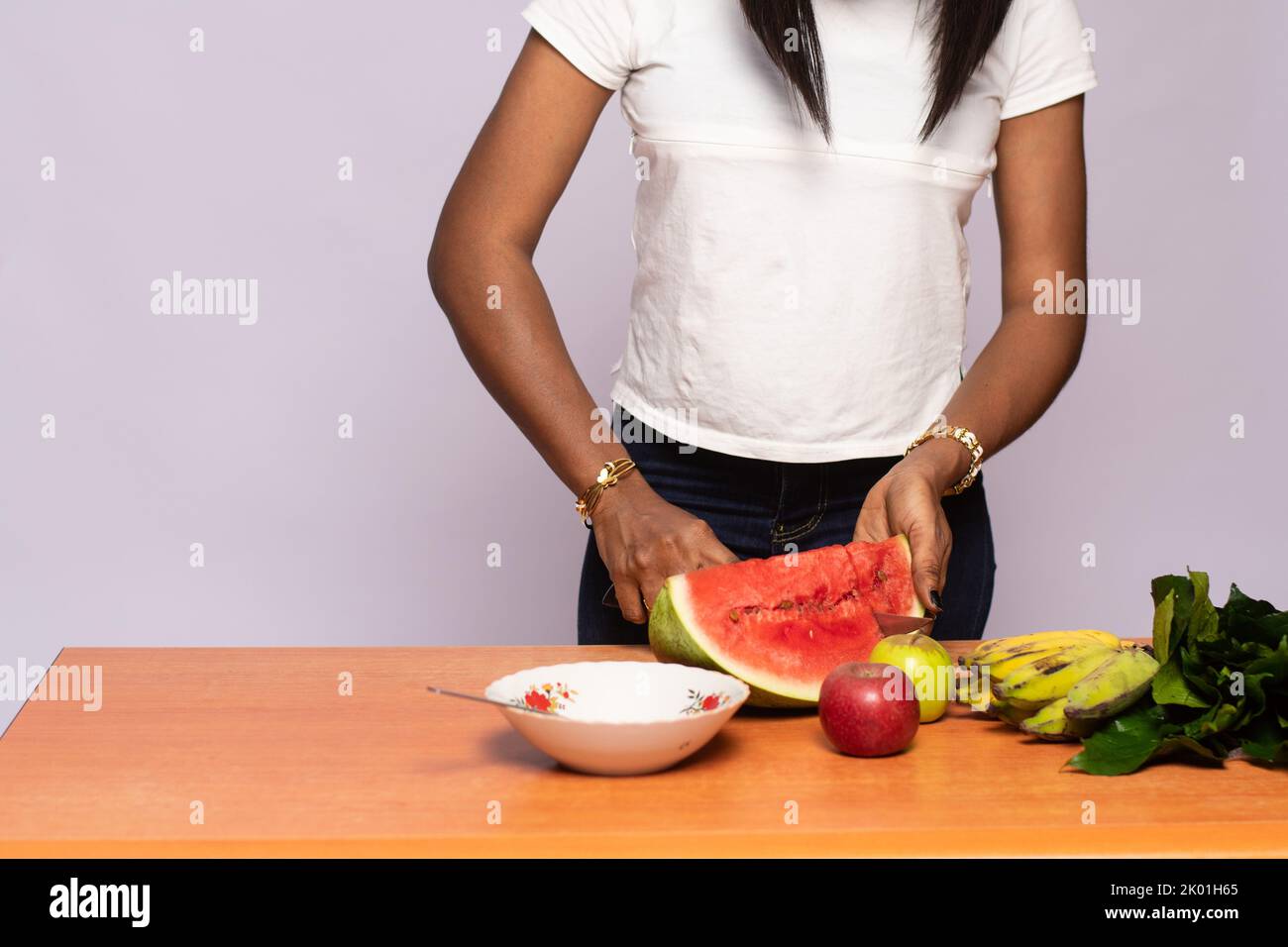 young black lady preparing mixed fruit salad Stock Photo