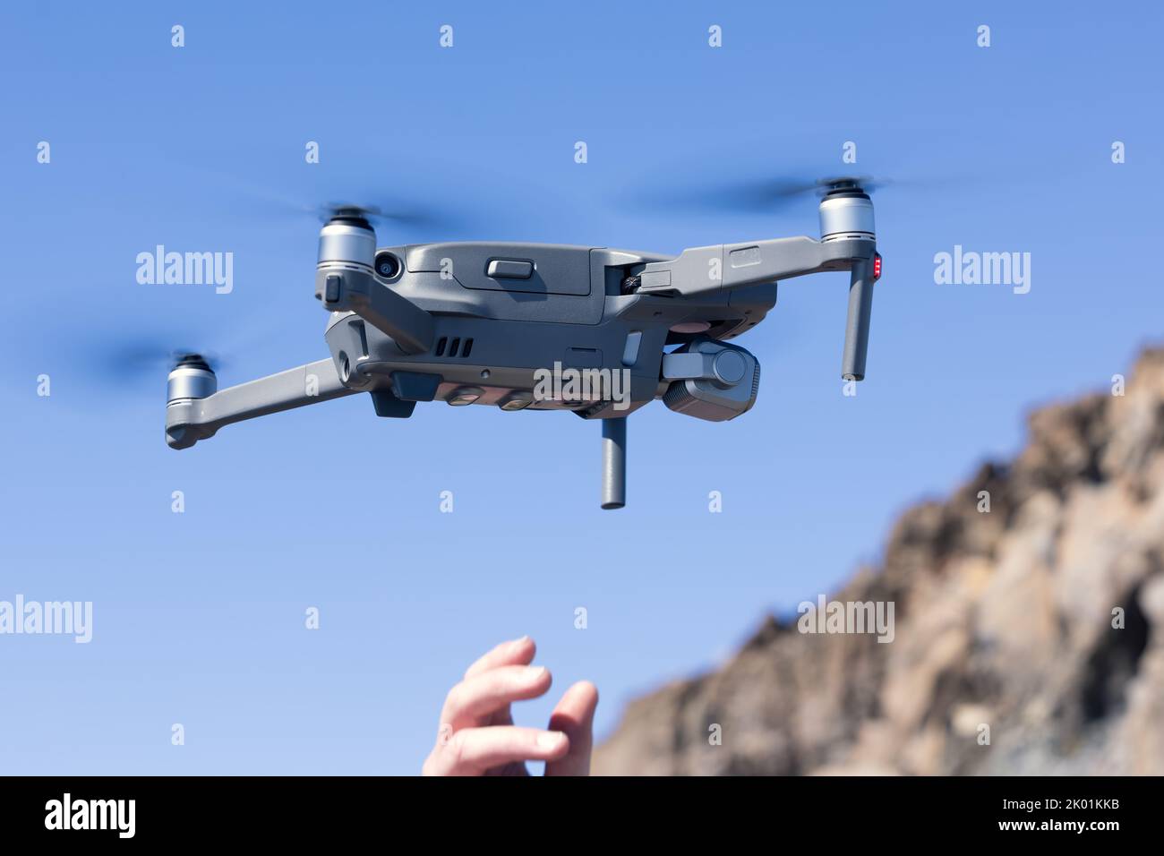 Man Hand launching a drone against blue sky Stock Photo