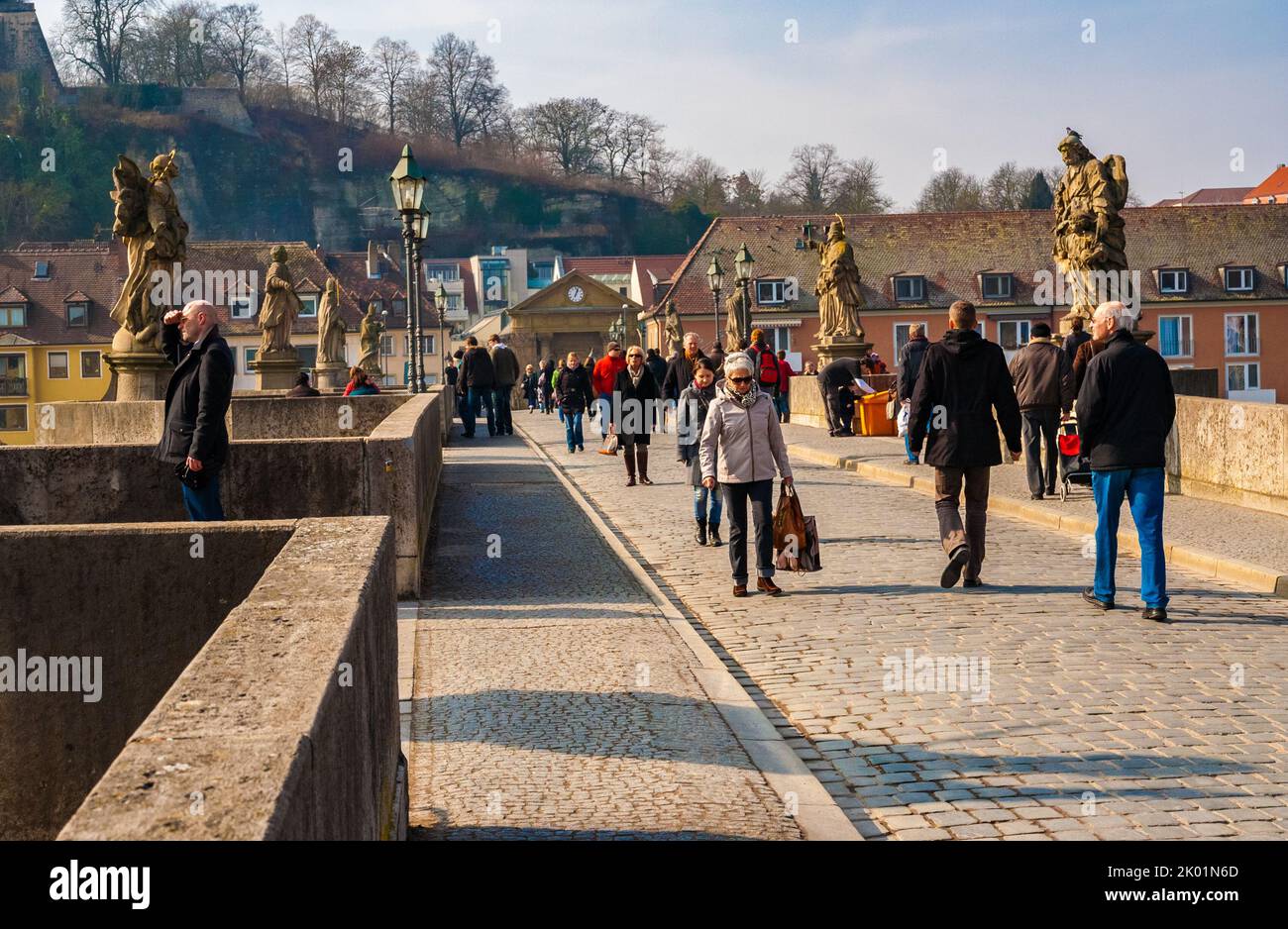 Close-up of people crossing the famous pedestrianized old bridge “Alte Mainbrücke” in Würzburg, Germany. The arch bridge over the Main river has 12... Stock Photo
