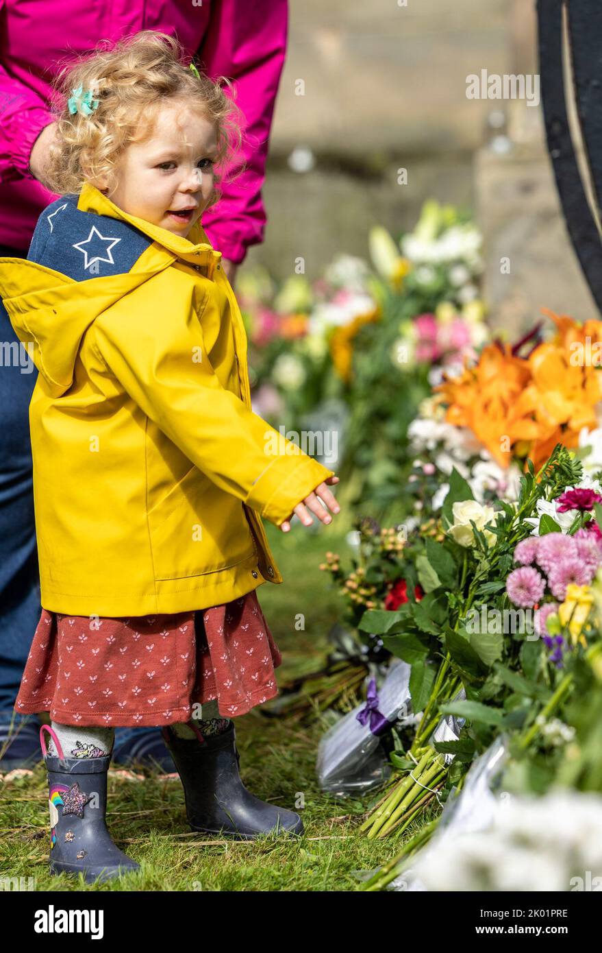 Edinburgh, United Kingdom. 09 September, 2022 Pictured: A child lays flowers at the Palace of Holyroodhouse in Edinburgh. Credit: Rich Dyson/Alamy Live News Stock Photo