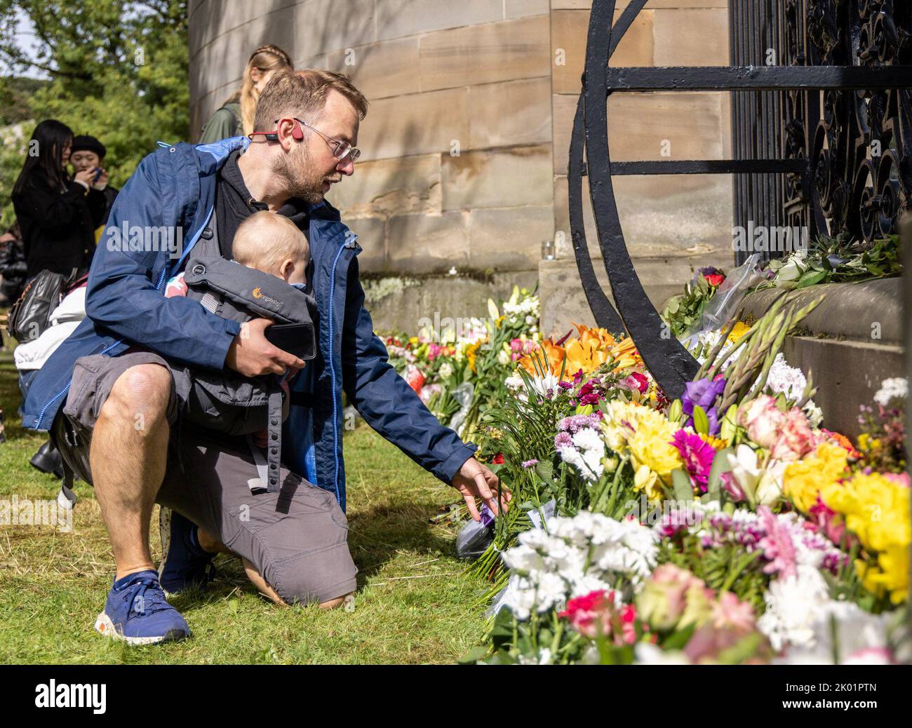 Edinburgh, United Kingdom. 09 September, 2022 Pictured: A mourner lays flowers at the Palace of Holyroodhouse in Edinburgh. Credit: Rich Dyson/Alamy Live News Stock Photo