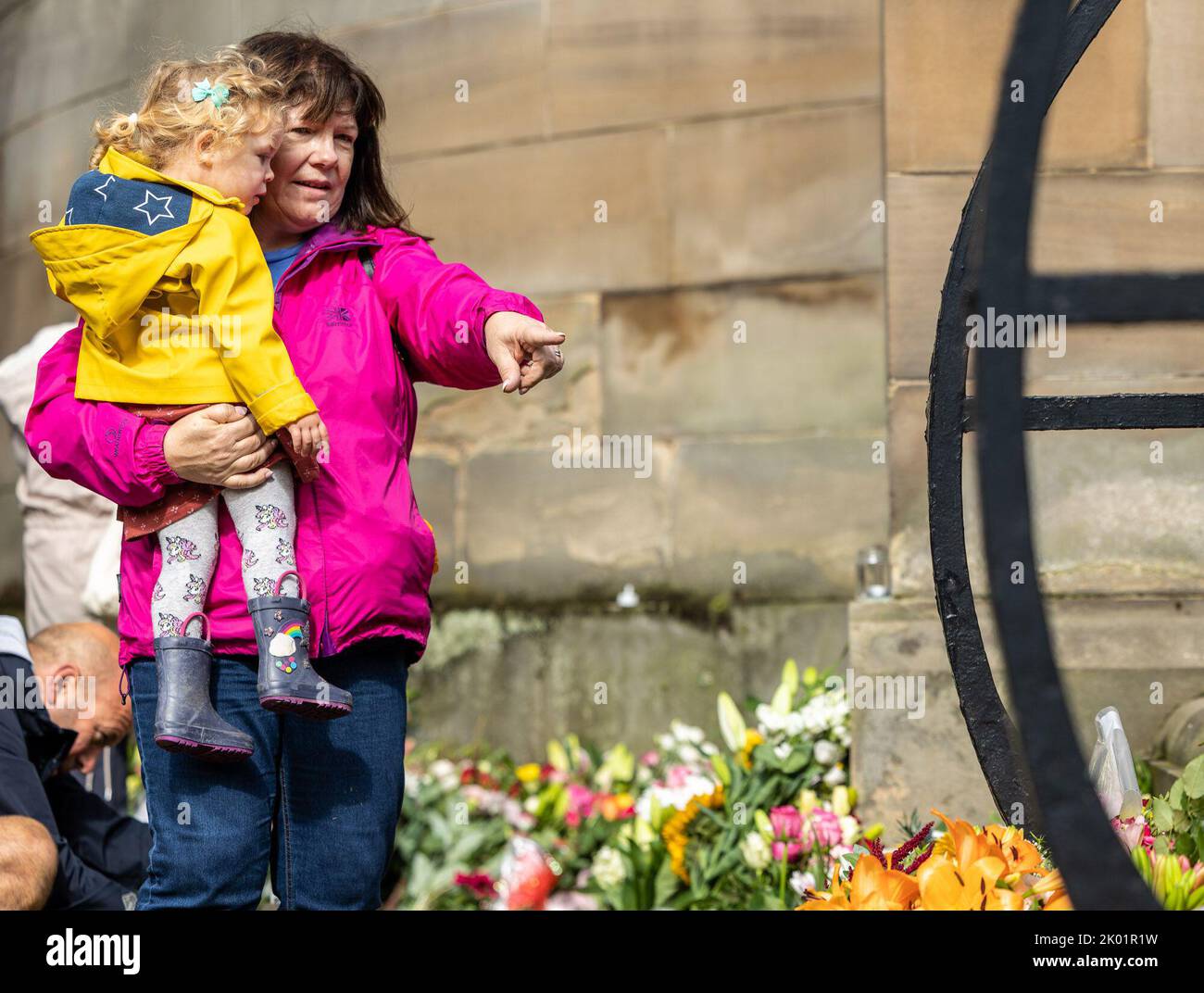 Edinburgh, United Kingdom. 09 September, 2022 Pictured: A mother and child lay flowers at the Palace of Holyroodhouse in Edinburgh. Credit: Rich Dyson/Alamy Live News Stock Photo