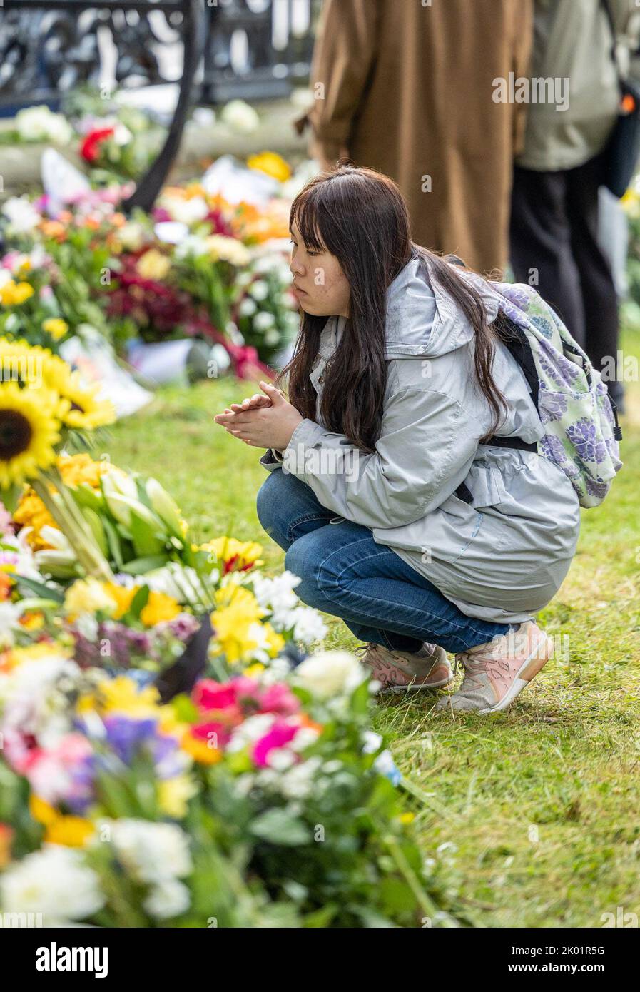 Edinburgh, United Kingdom. 09 September, 2022 Pictured: A mourner offers a prayer after laying flowers at the Palace of Holyroodhouse in Edinburgh. Credit: Rich Dyson/Alamy Live News Stock Photo