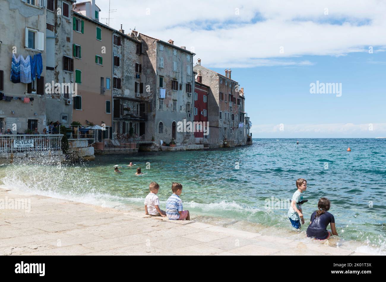 Children playing in the water on the embankment of the historic town of Rovinj, Croatia, Europe Stock Photo