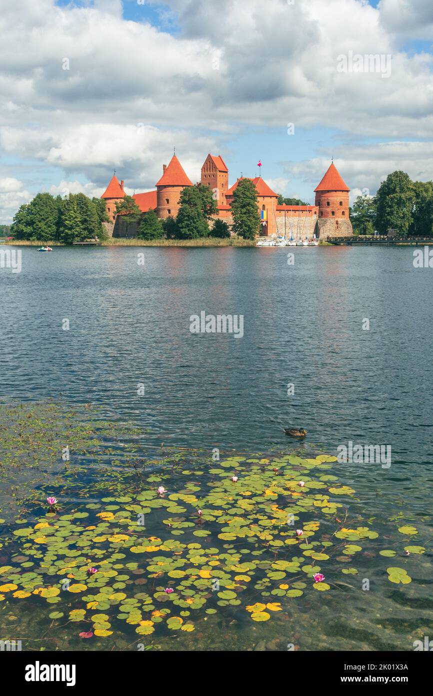 Medieval castle of Trakai, Vilnius, Lithuania, Eastern Europe, surrounded by beautiful lakes and nature in summer with water lilies and wooden bridge Stock Photo