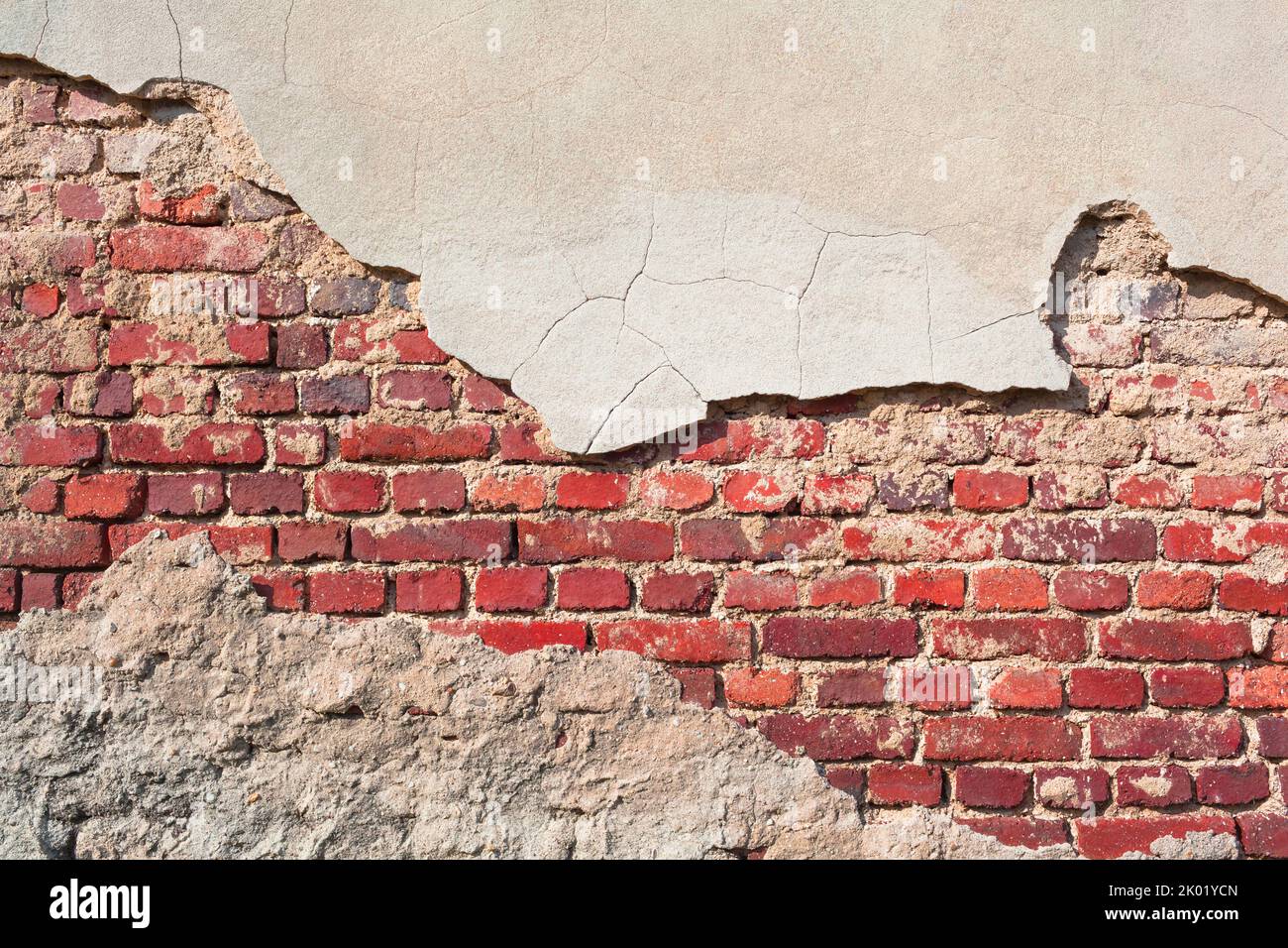 Old brick wall background with partly chipped cement plaster (copy space) Stock Photo
