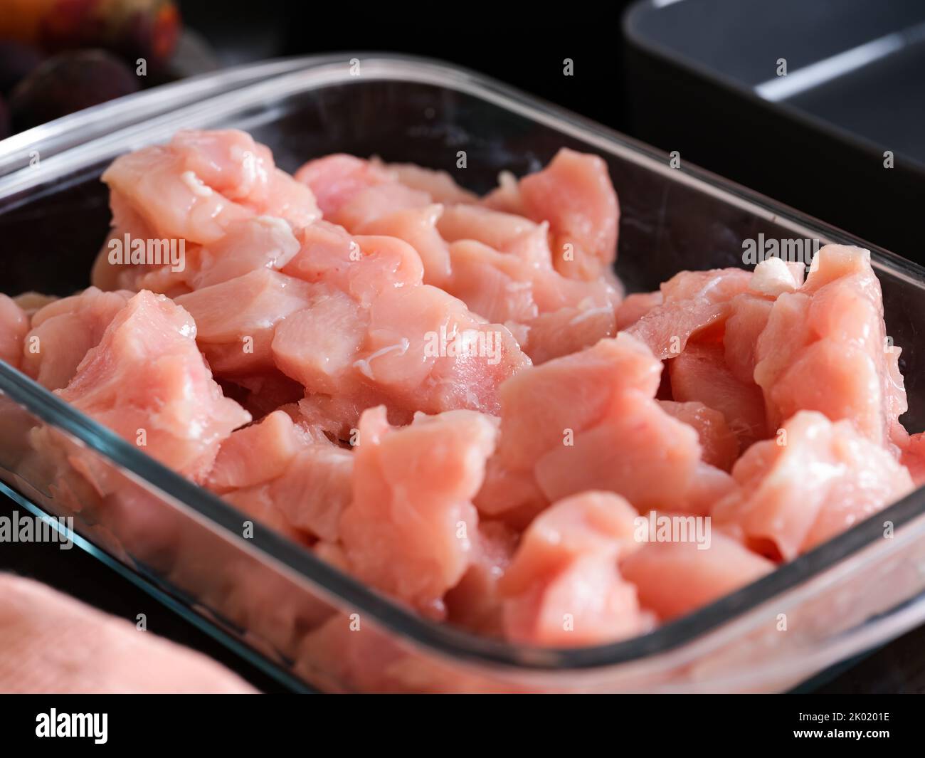 Pieces of raw chicken fillet in a glass baking tray. Close-up Stock Photo
