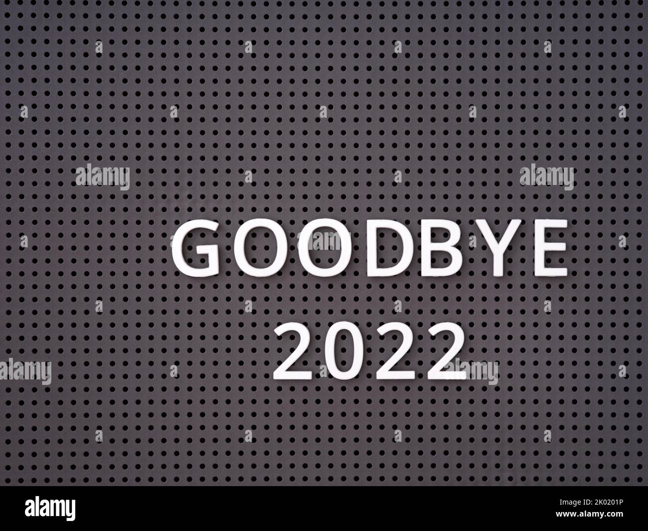 Words Goodbye 2022 spelled out with white letters on a gray pegboard Stock Photo