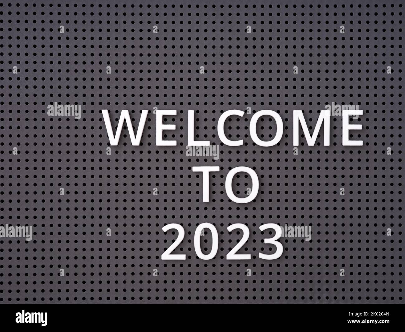 Words Welcome to 2023 spelled out with white letters on a gray pegboard Stock Photo