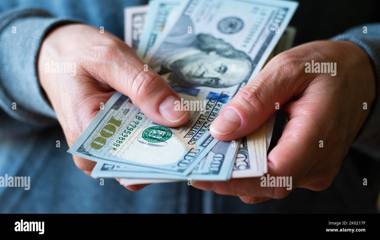 White female model shows dollar bills in her hand closeup front view Stock Photo