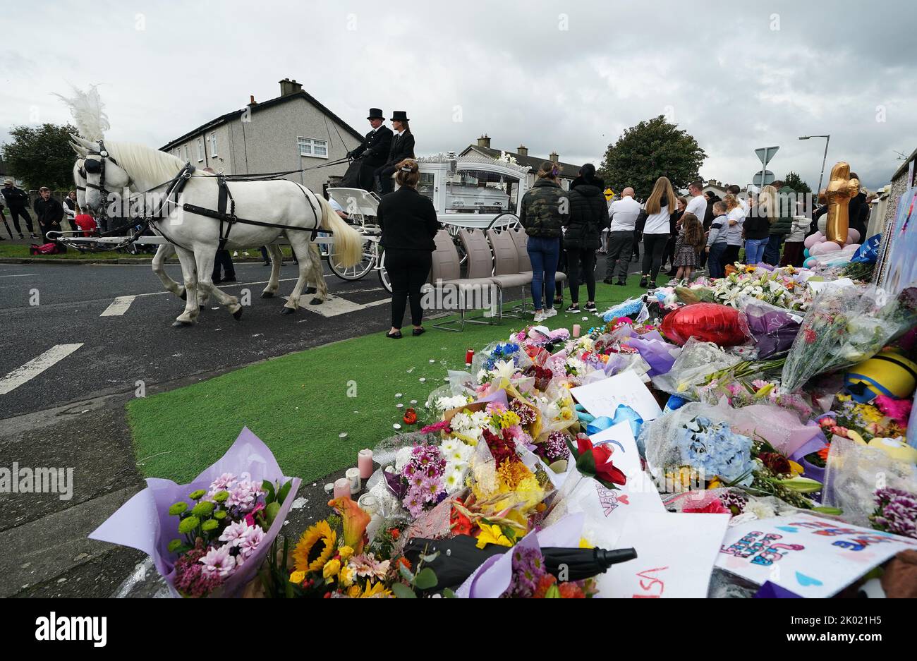 The funeral procession stops outside a house on Rossfield Avenue in