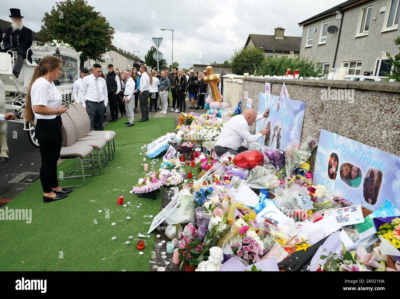 The funeral procession stops outside a house on Rossfield Avenue in