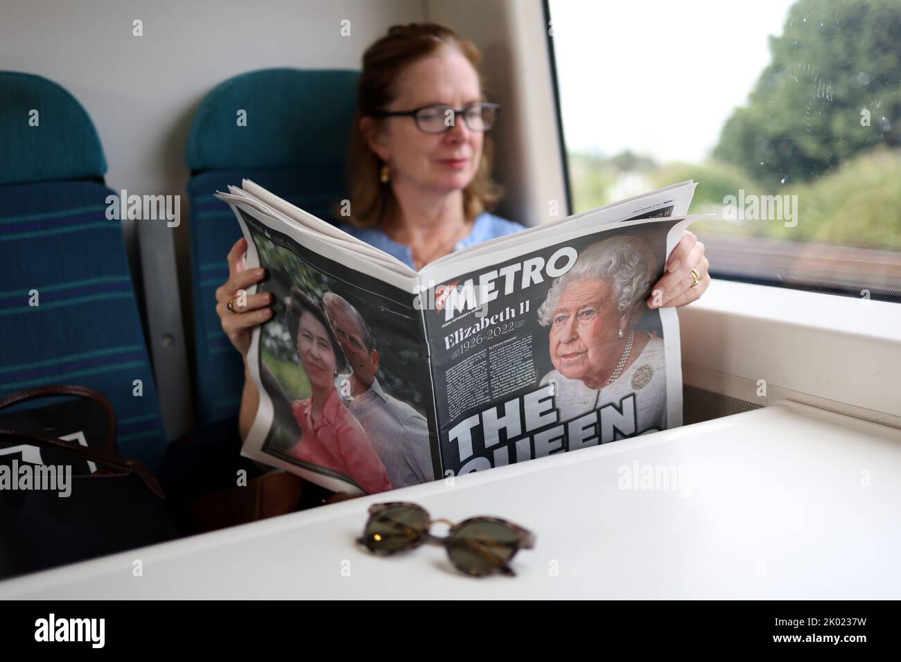 London, UK. 8th Sep, 2022. A woman reading an edition of Metro with the headline The Queen is Dead travelling on a train into London. Credit: James Boardman/Alamy Live News Stock Photo
