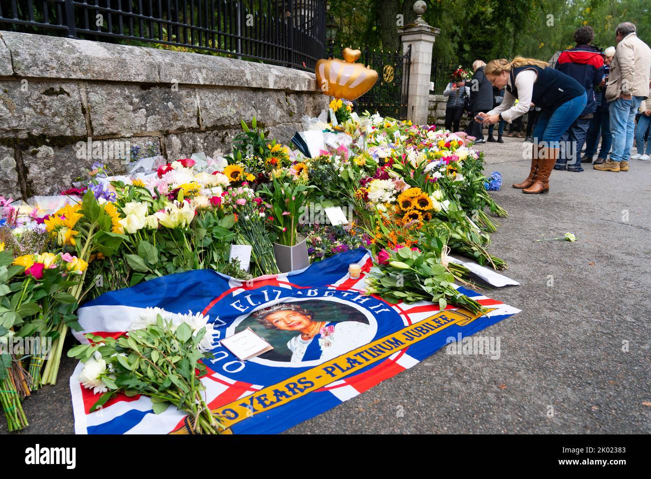 Balmoral, Scotland, UK. 9th September 2022. Members of the public laying flowers at the entrance gates to Balmoral Castle following news of death of HRH Queen Elizabeth II yesterday.  Iain Masterton/Alamy Live News Stock Photo