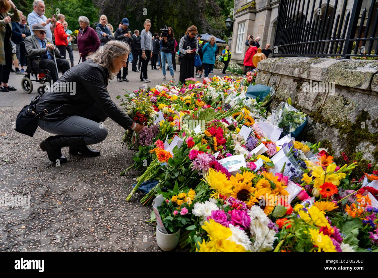 Balmoral, Scotland, UK. 9th September 2022. Members of the public laying flowers at the entrance gates to Balmoral Castle following news of death of HRH Queen Elizabeth II yesterday.  Iain Masterton/Alamy Live News Stock Photo